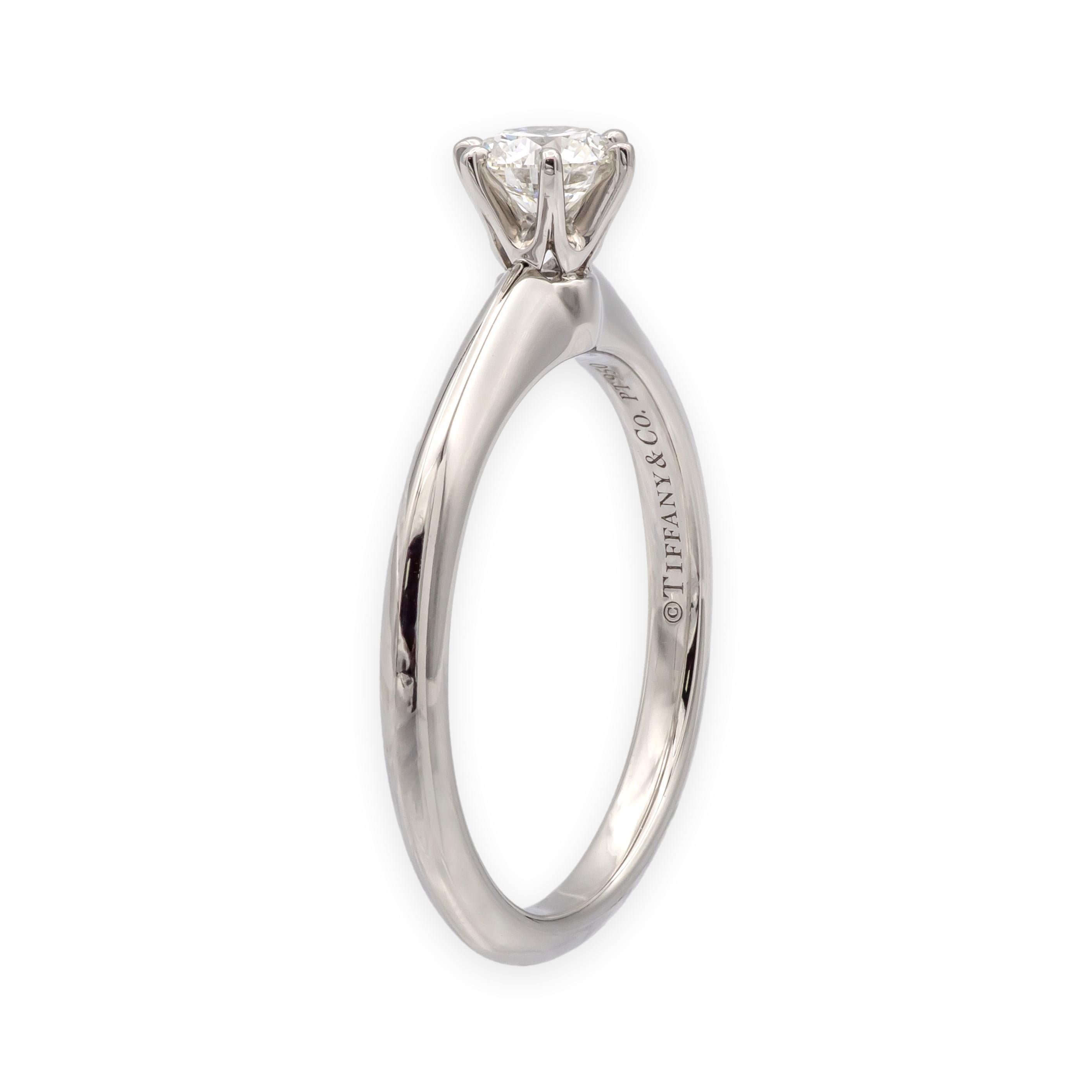 Solitaire classique en platine de Tiffany & Co. orné d'un diamant rond de 0,28 ct de taille brillant solidement serti sur un anneau élégant et confortable. Le poinçon, le poids et la série sont présents et clairement lisibles. Comme toutes les