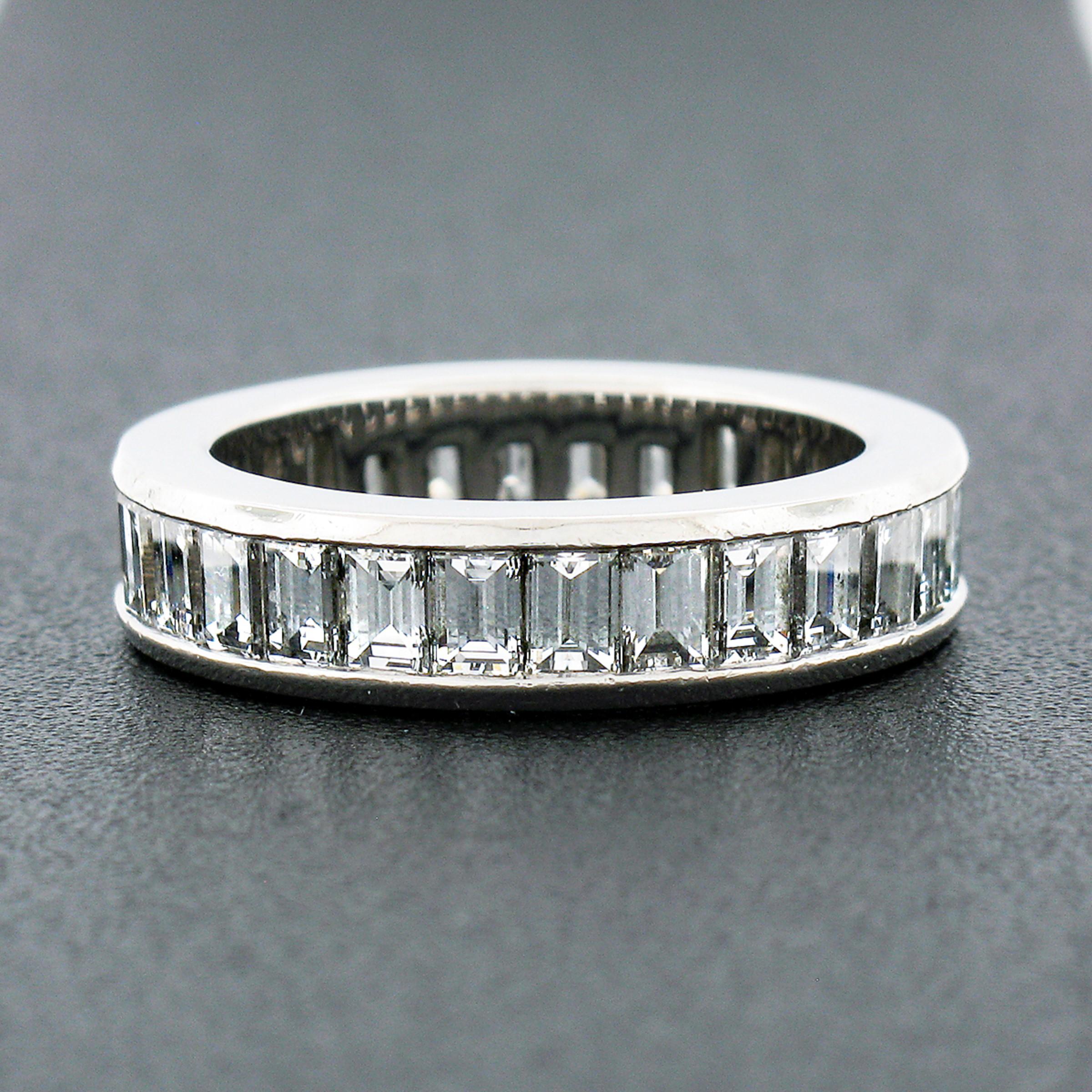 This absolutely gorgeous diamond eternity band is crafted in solid .950 platinum and designed by Tiffany & Co. featuring SUPER FINE quality straight baguette cut diamonds neatly channel set entirely throughout. The ring contains 28 diamonds which