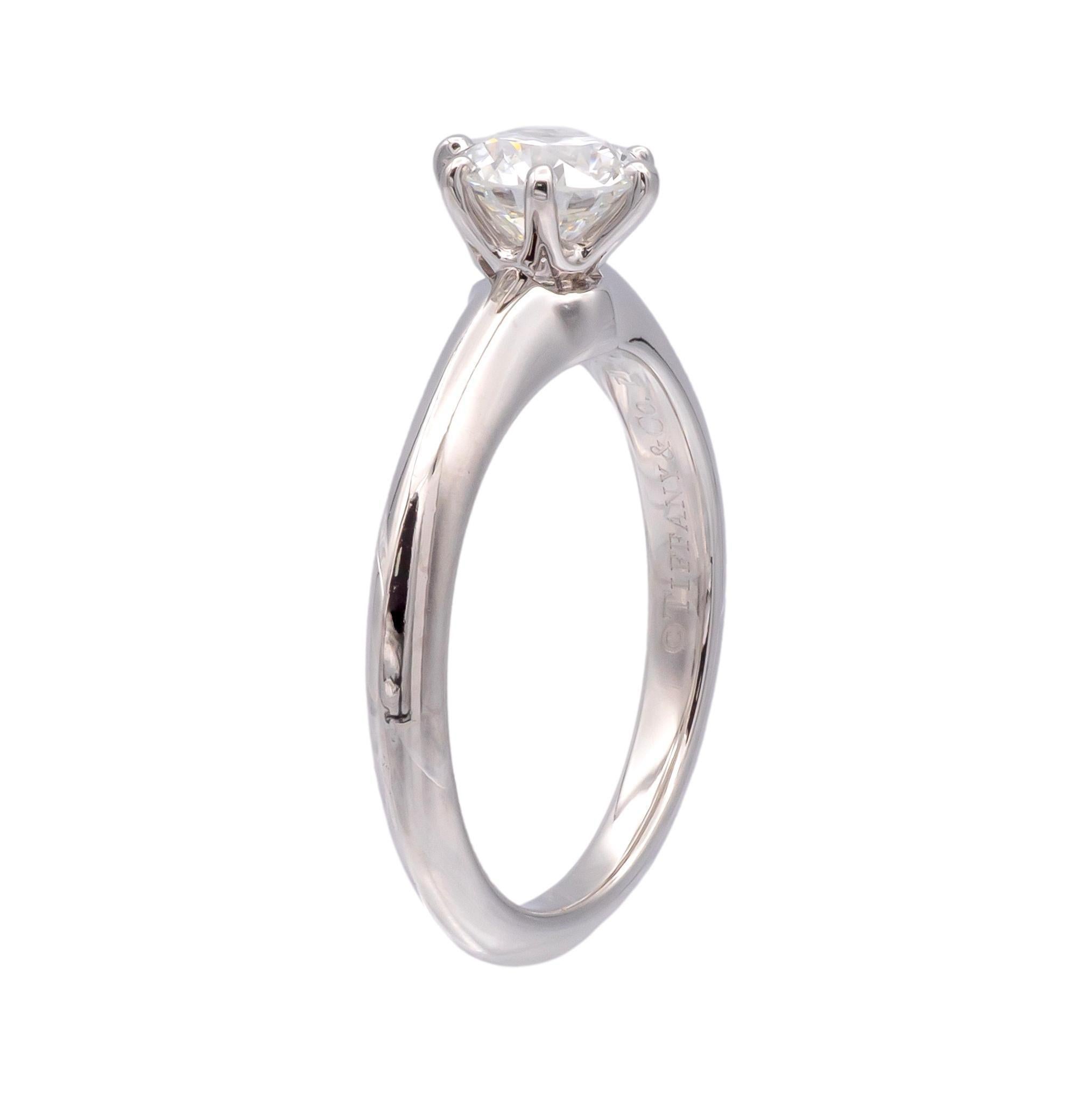 This Tiffany & Co. Classic Solitaire Engagement Ring features a 0.74-carat round brilliant diamond, set in a platinum band with a graceful taper from 3.0 mm to 1.9 mm. The diamond, graded H color and VS2 clarity, has an excellent cut, polish, and