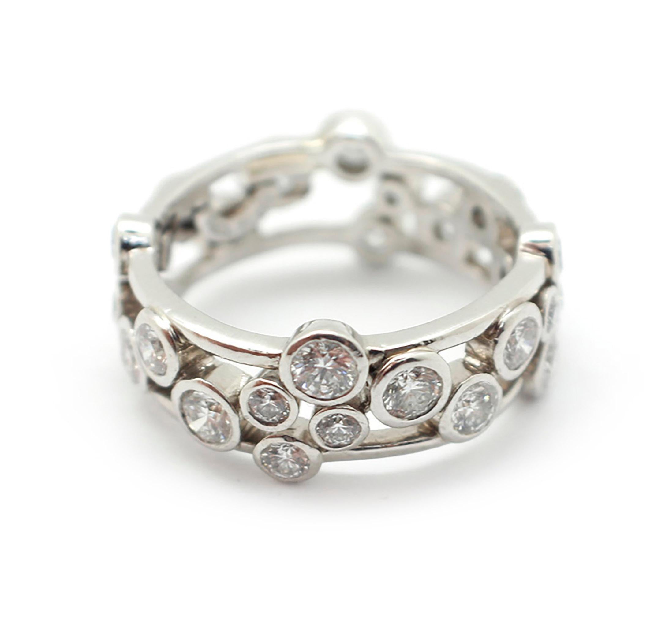 The band style ring is crafted in platinum by designer Tiffany & Co. It features bezel set, round brilliant-cut diamonds all around. The diamonds have a total weight of 1.60ct and are graded G in color and VS in clarity. The ring measures 4.5mm wide