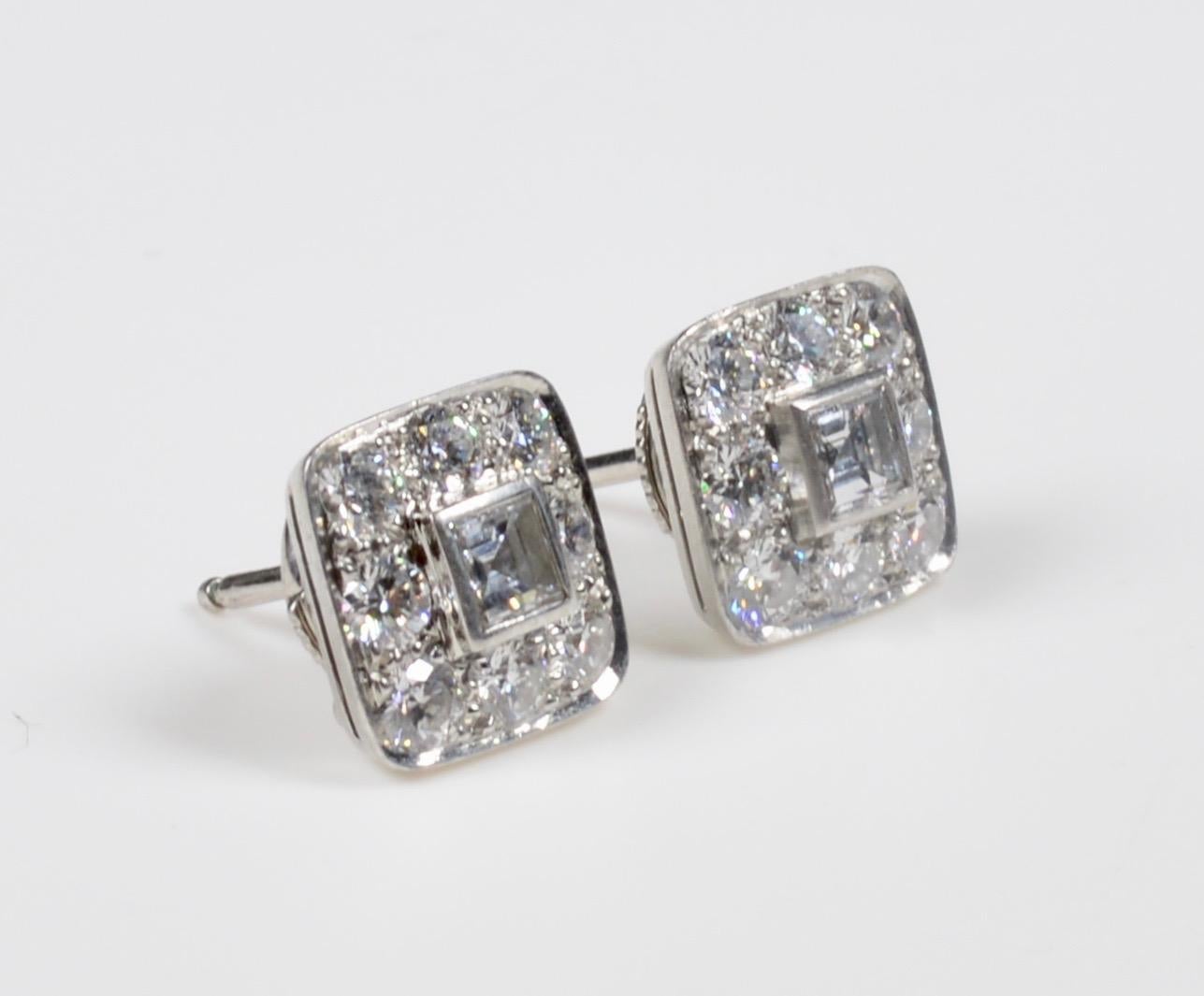 A Tiffany & Co. pair of platinum and diamond earrings, containing two square step cut diamonds weighing approximately 0.30 carat each and 16 round brilliant cut diamonds weighing approximately 0.96 carat. Toral Carat approximately is 2.4
Stamp: