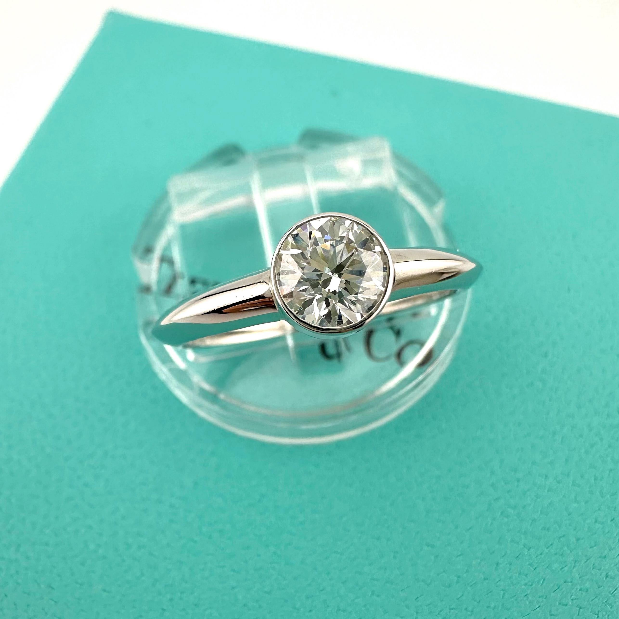 Tiffany & Co Bezet Diamond Engagement Ring
Style:  Bezel Set
Ref. number:  I0627****
Metal:  Platinum PT950
Size / Measurements:  6.25 sizable
TCW:  0.57 cts
Main Diamond:  Round Brilliant Diamond 
Color & Clarity:  F, VS1
Diamond Inscription: 