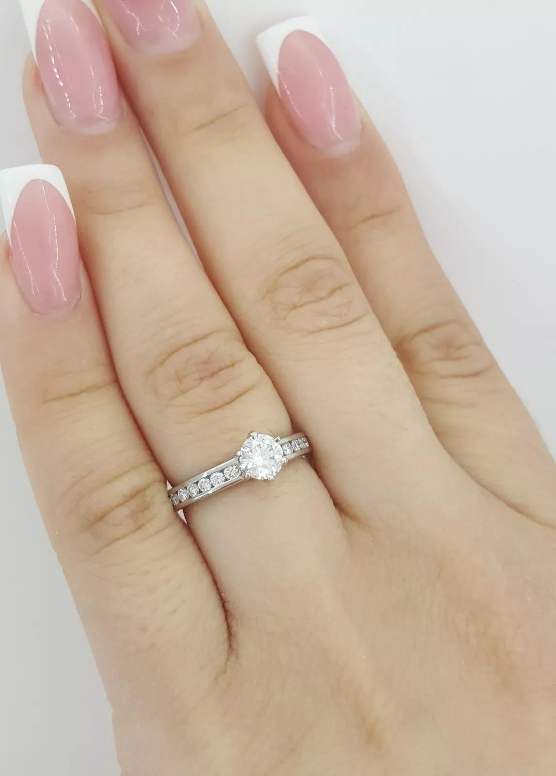 Tiffany & Co. Platinum Channel-Set Diamond Engagement Ring featuring a 0.41 ct Round Brilliant Center Diamond.

This timeless piece weighs 3.8 grams and is a size 4. The center stone is a 0.41 ct Natural Round Brilliant Cut diamond, E in color, VS1