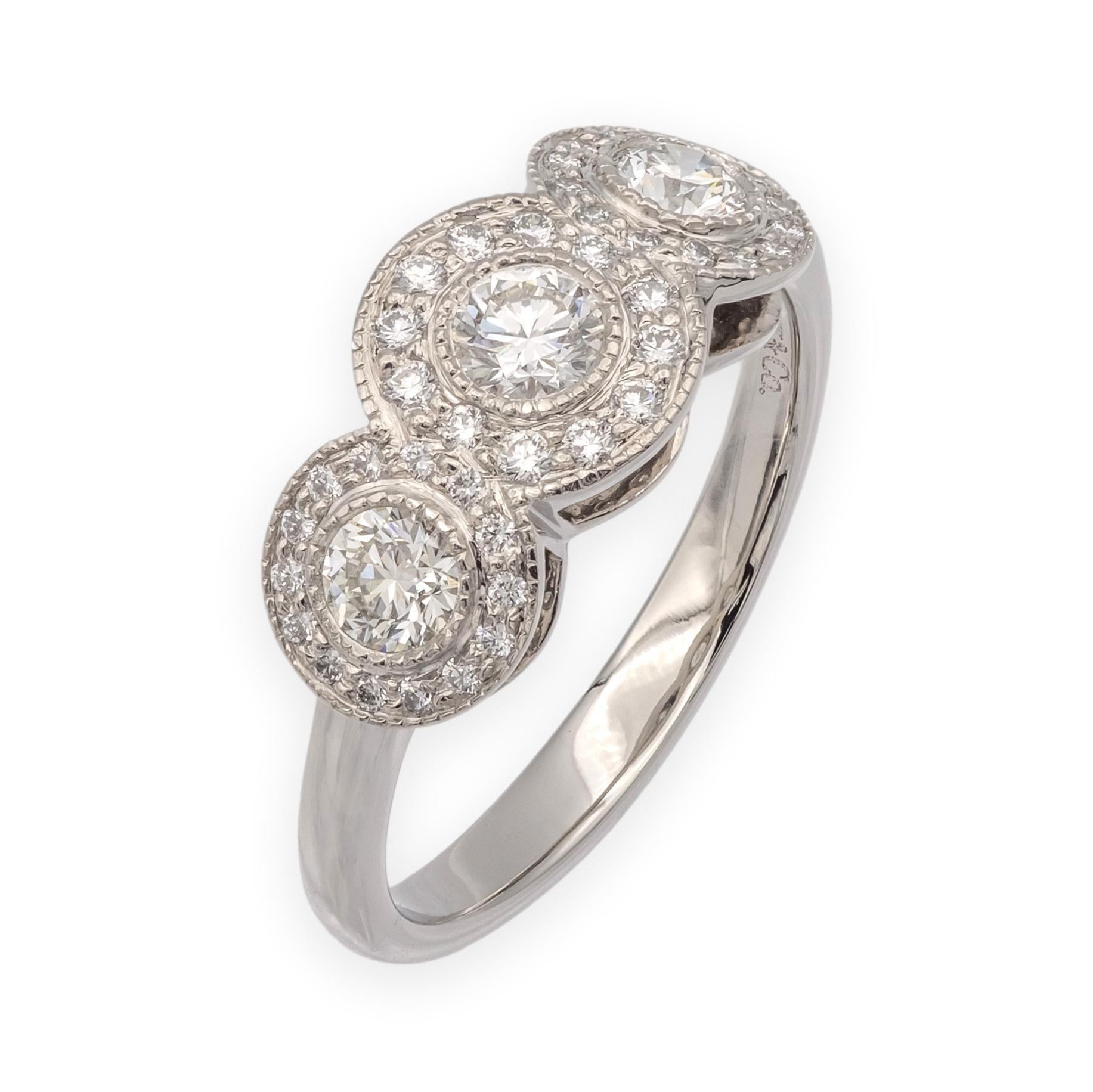 Tiffany & Co. Circlet three-stone diamond ring crafted in platinum. The design features three round brilliant center diamonds surrounded by micro pavé diamond halos. The three central stones total approximately 0.55 carats, complemented by