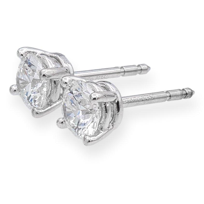 Pair of Tiffany & Co. Diamond Stud earrings finely crafted in a Platinum 4 prong basket setting featuring two perfectly matched round brilliant cut diamonds weighing 1.42 carats total weight. One round brilliant diamond weighs 0.71 carats graded F