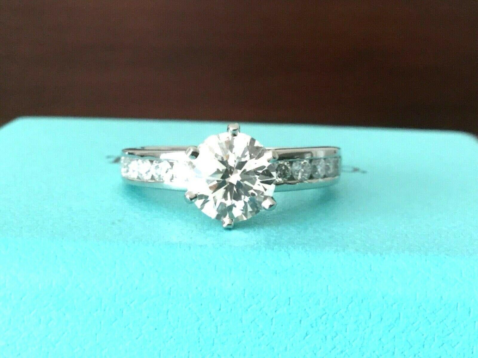 Being offered for your consideration is a like new classic Tiffany & Co Platinum and Diamond 1.17 carat natural Round engagement ring set in the classic channel set diamond band (TOTAL CARAT WEIGHT IS 1.50 carats)..  This ring was hardly worn and