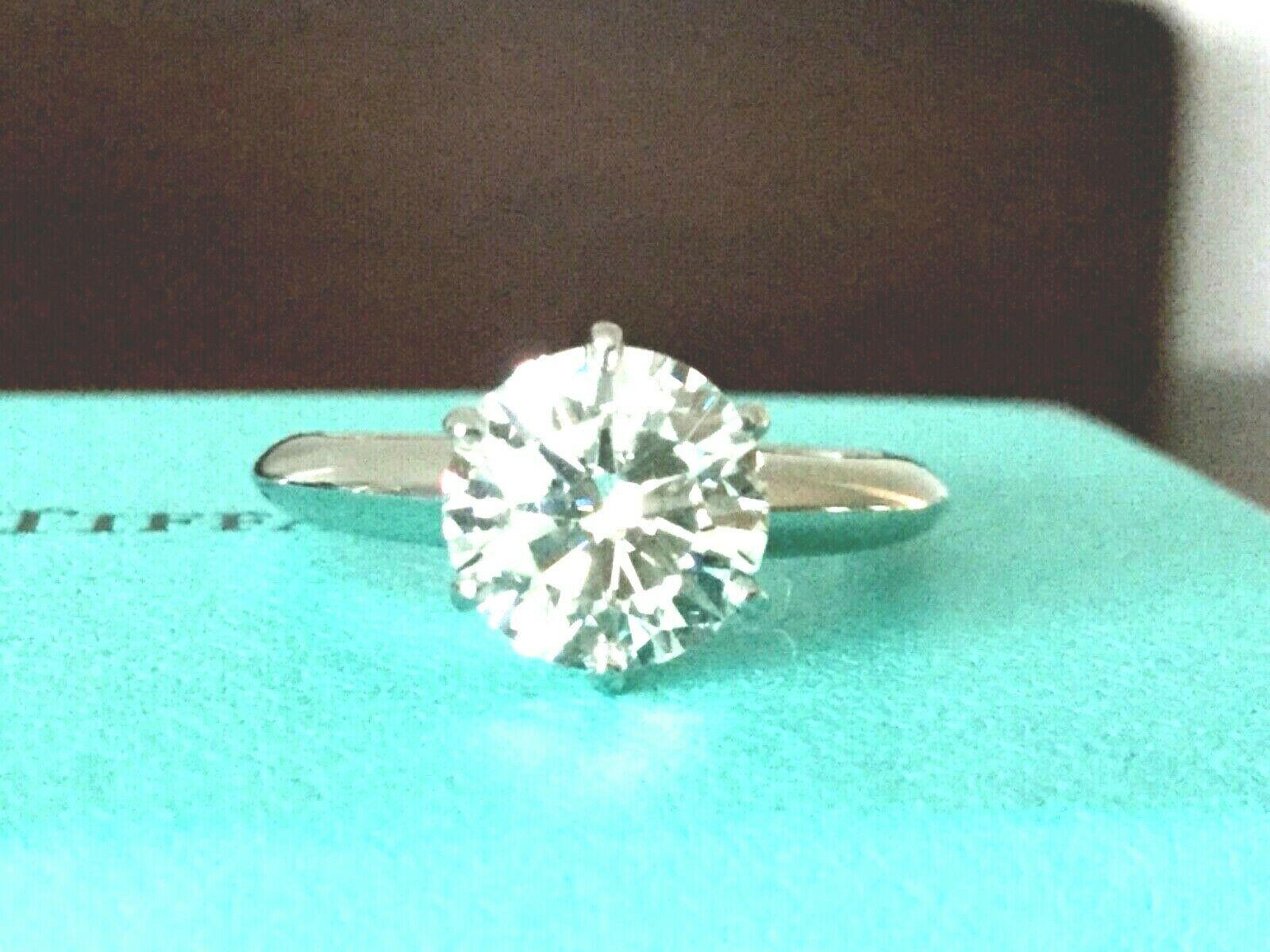 Being offered for your consideration is a like new Tiffany & Co Platinum and Diamond 1.71 carat natural round engagement ring set in the classic 6 prong setting.  

This stunning diamond looks HUGE, Super White and Super Fiery - it is a magnificent