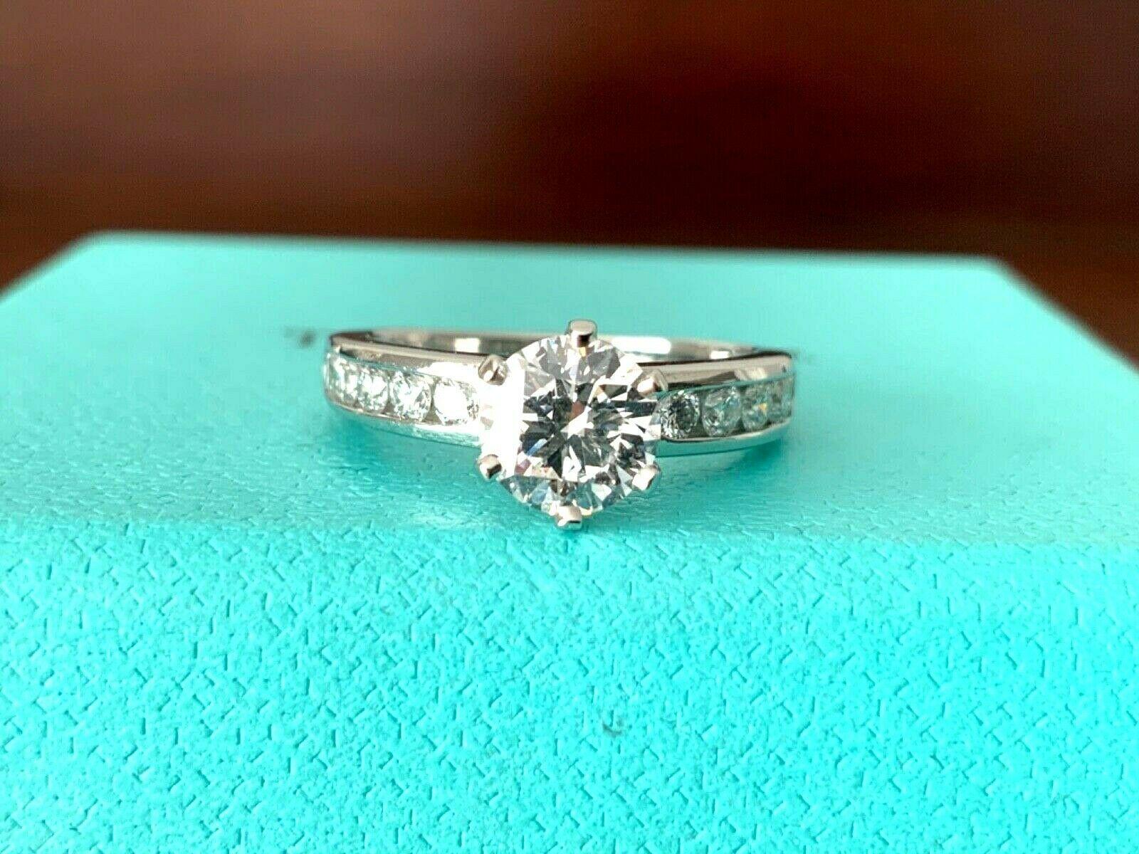 Being offered for your consideration is a like new classic Tiffany & Co Platinum and Diamond .83 carat natural Round engagement ring set in the classic channel set diamond band (TOTAL CARAT WEIGHT IS 1.10 carats)..  This ring was hardly worn and can
