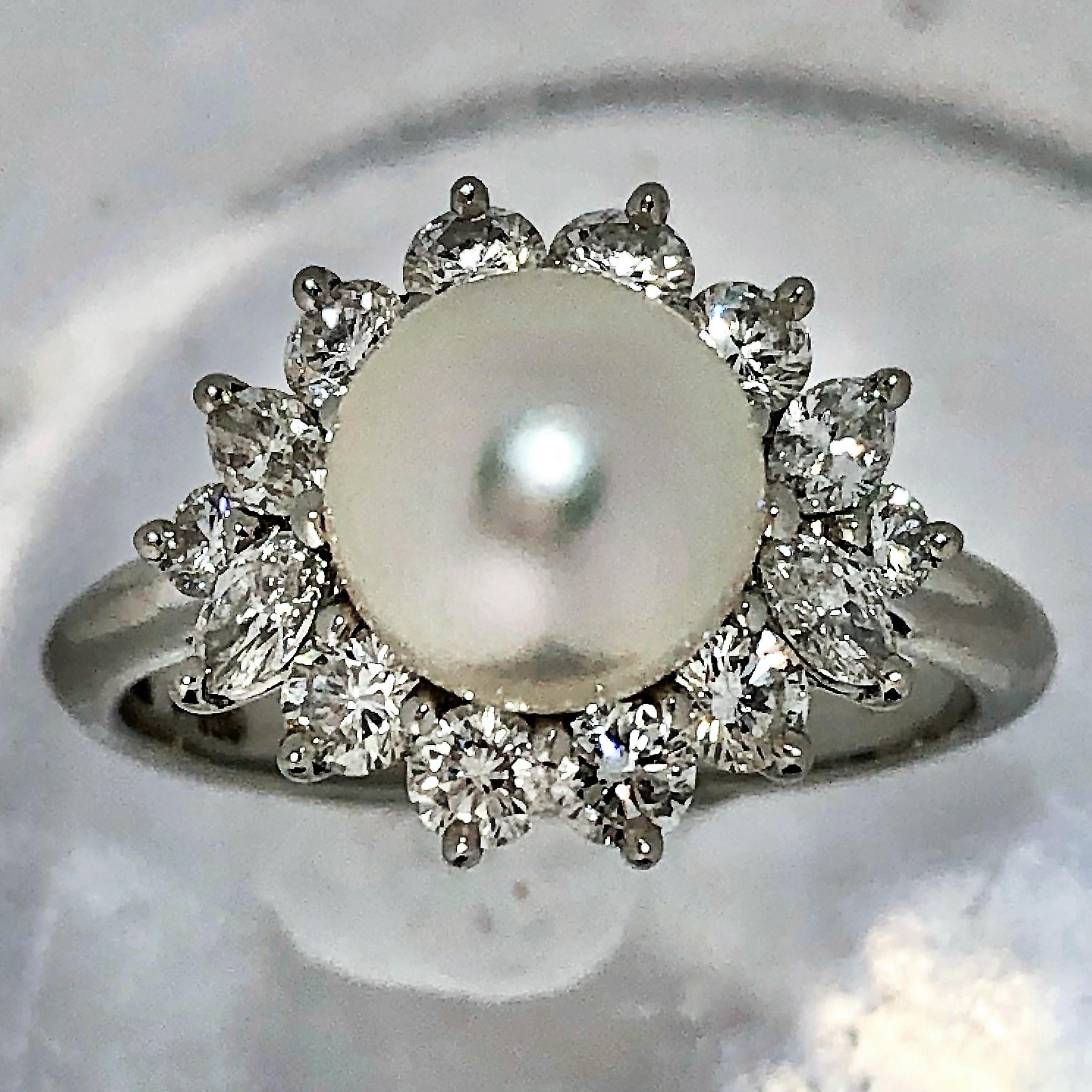 A platinum ring by Tiffany and Company centered around an 7.7 mm pearl in a classically 
inspired ballerina style setting, with 0.85 carats of round brilliant cut and marquise cut 
diamonds of overall F Color and VVS1 Clarity. The pearl is white