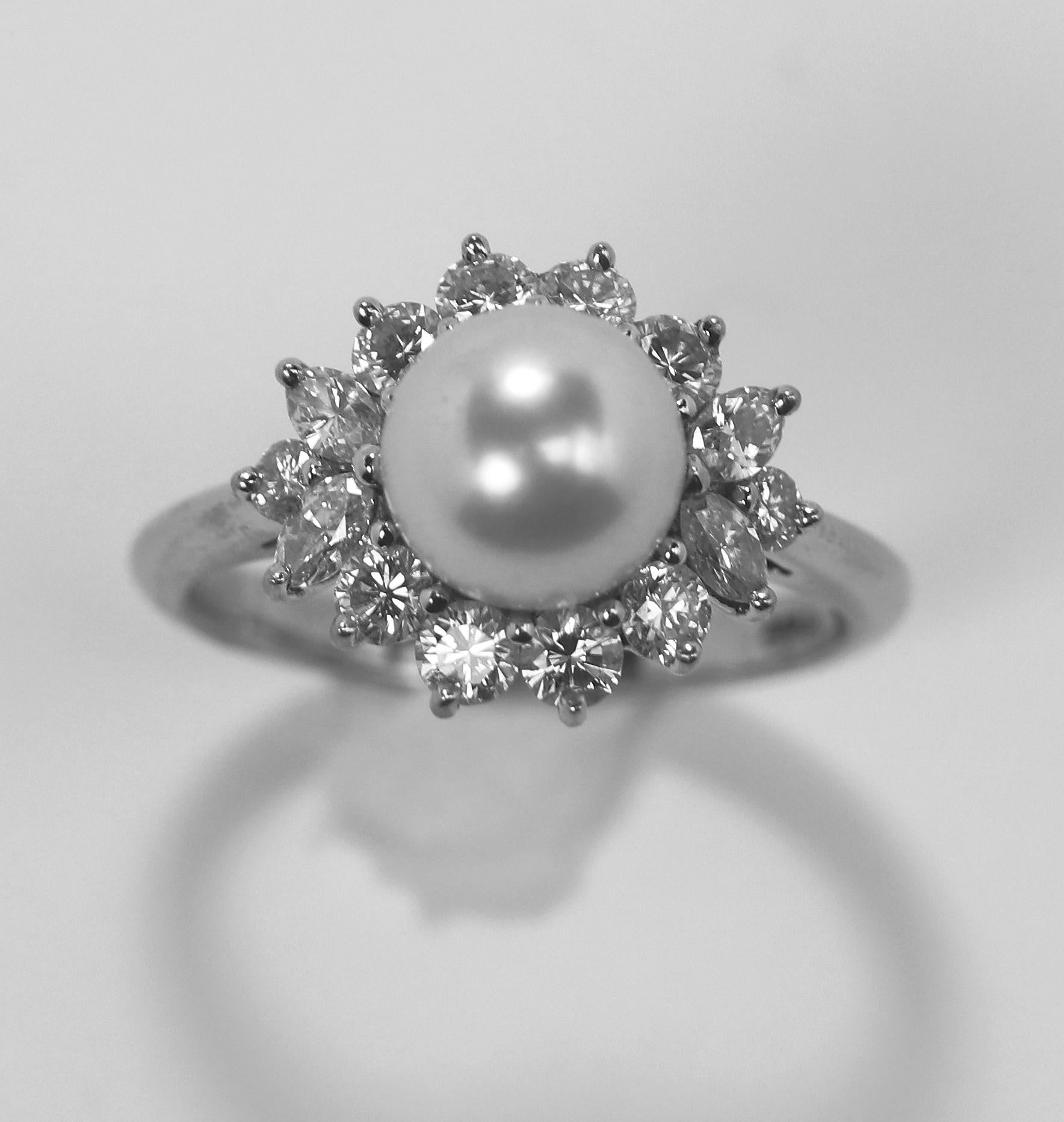 A platinum ring by Tiffany and Company centered around an 7.7 mm pearl in a classically inspired ballerina style setting, with 0.85 carats of round brilliant cut and marquise cut diamonds of overall F Color and VVS1 Clarity. The pearl is white with