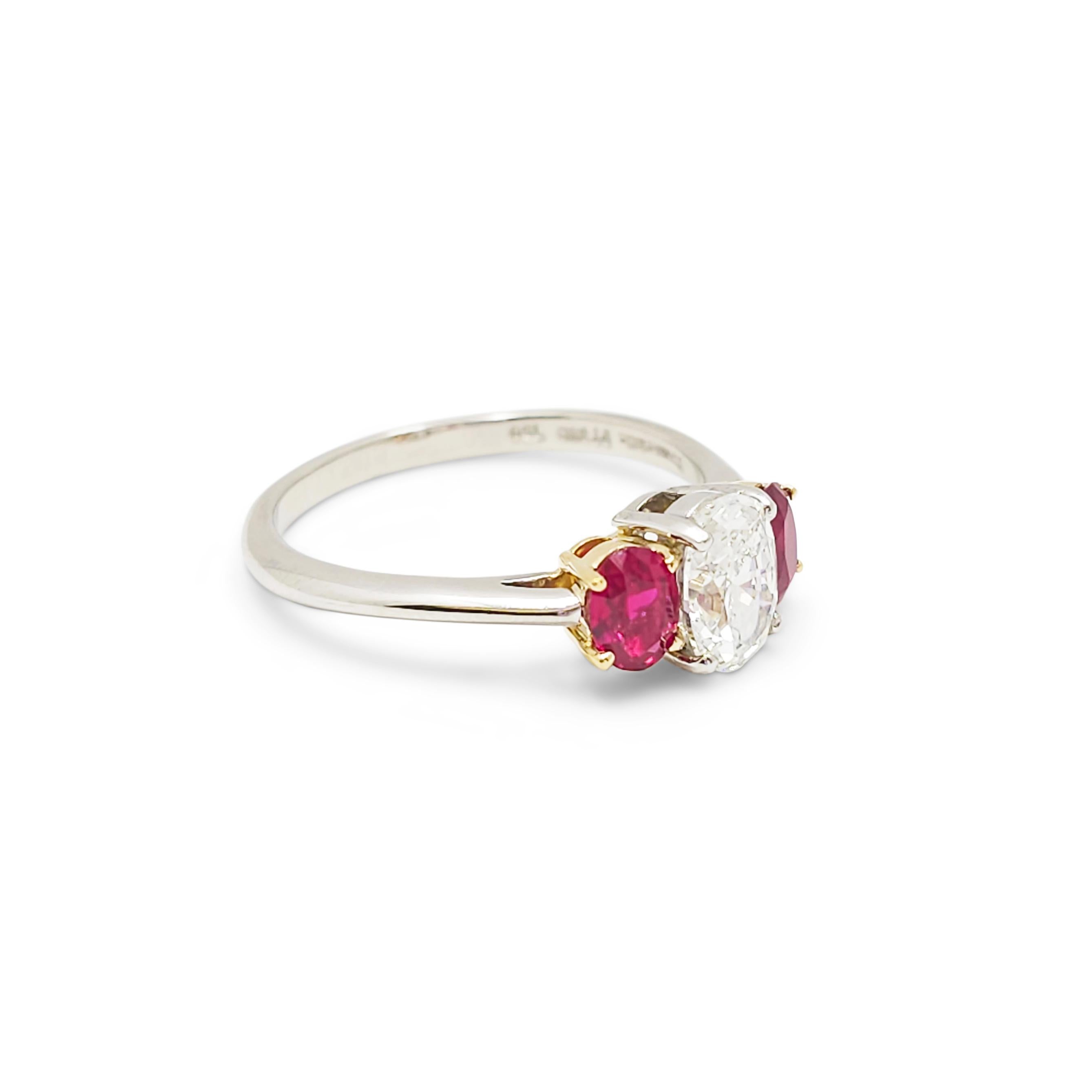 Authentic Tiffany & Co. ring crafted in platinum and set with a gorgeous 1.00 carat GIA certified oval cut diamond (G/VVS2) and two lively rubies or approximately .90 carats total weight.  The rubies are set in 18 karat yellow gold baskets.  US size