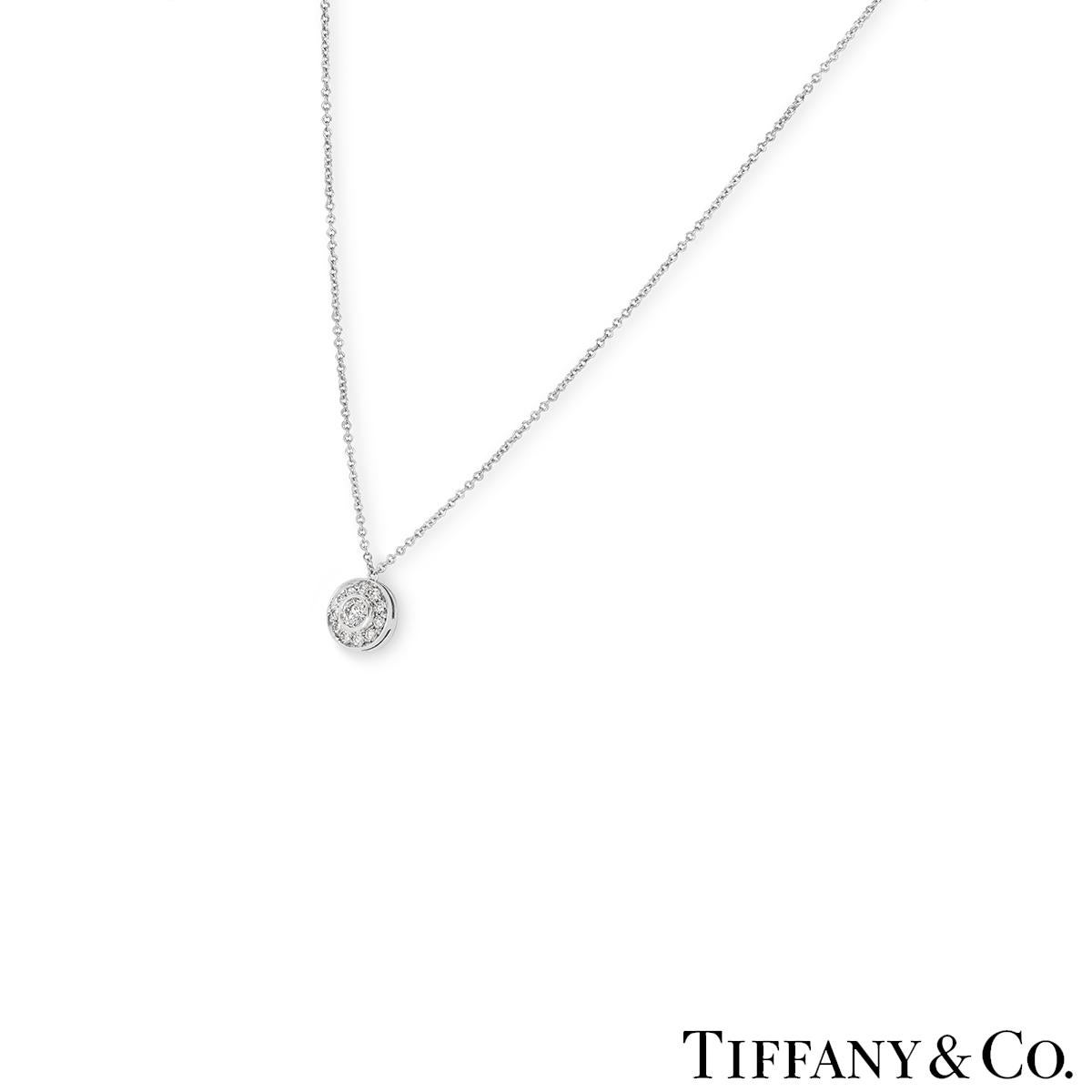 A charming platinum diamond pendant by Tiffany & Co from the Circlet collection. The pendant is bezel set to the centre with a round brilliant cut diamond weighing approximately 0.15ct, F colour and VS clarity. Accentuating the centre diamond is a