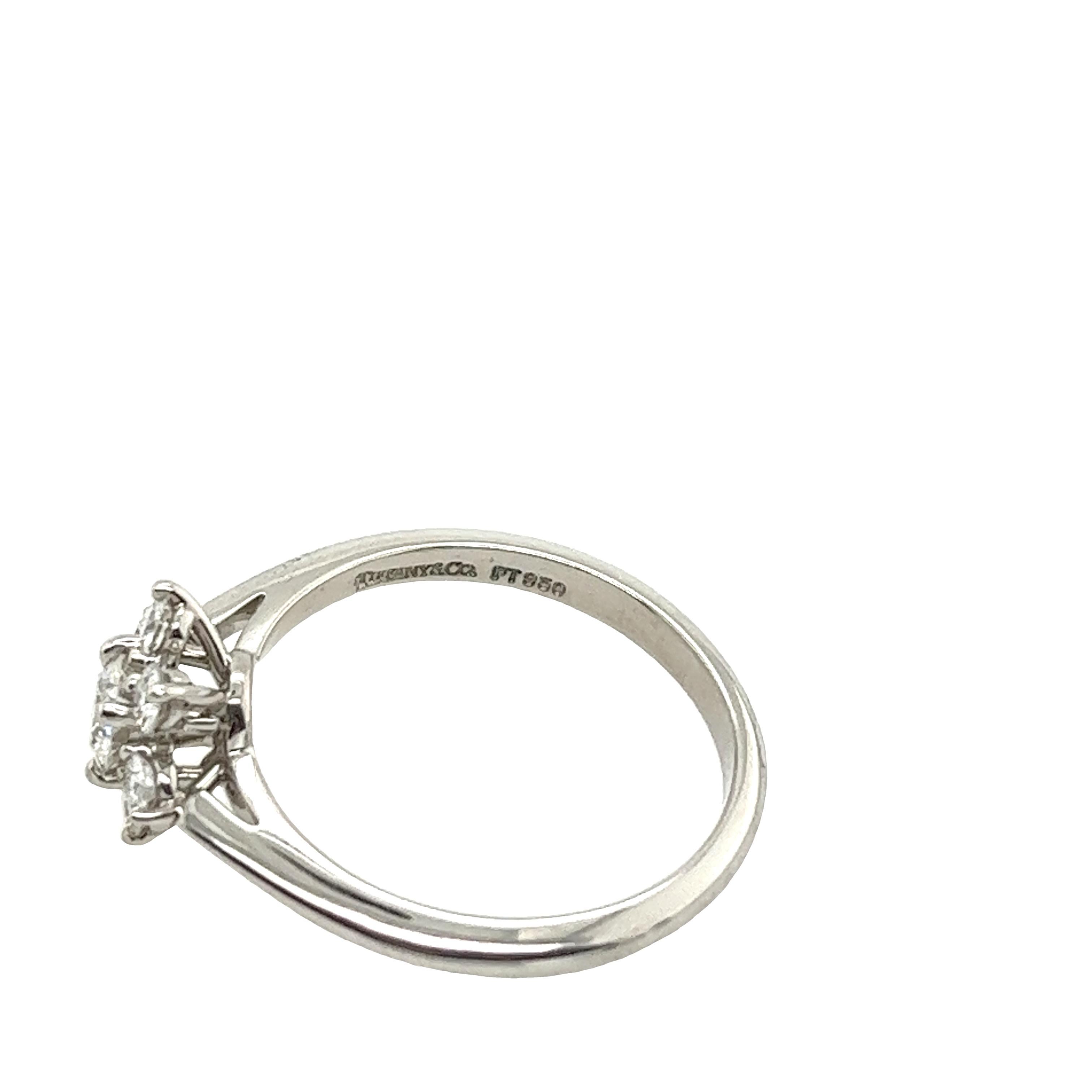 Embrace unparalleled elegance with the Tiffany & Co. Platinum Diamond Cluster Ring. This exquisite piece features seven round diamonds totaling 0.45 carats, graded at G/VS for exceptional quality. Set in platinum, the diamonds form a captivating