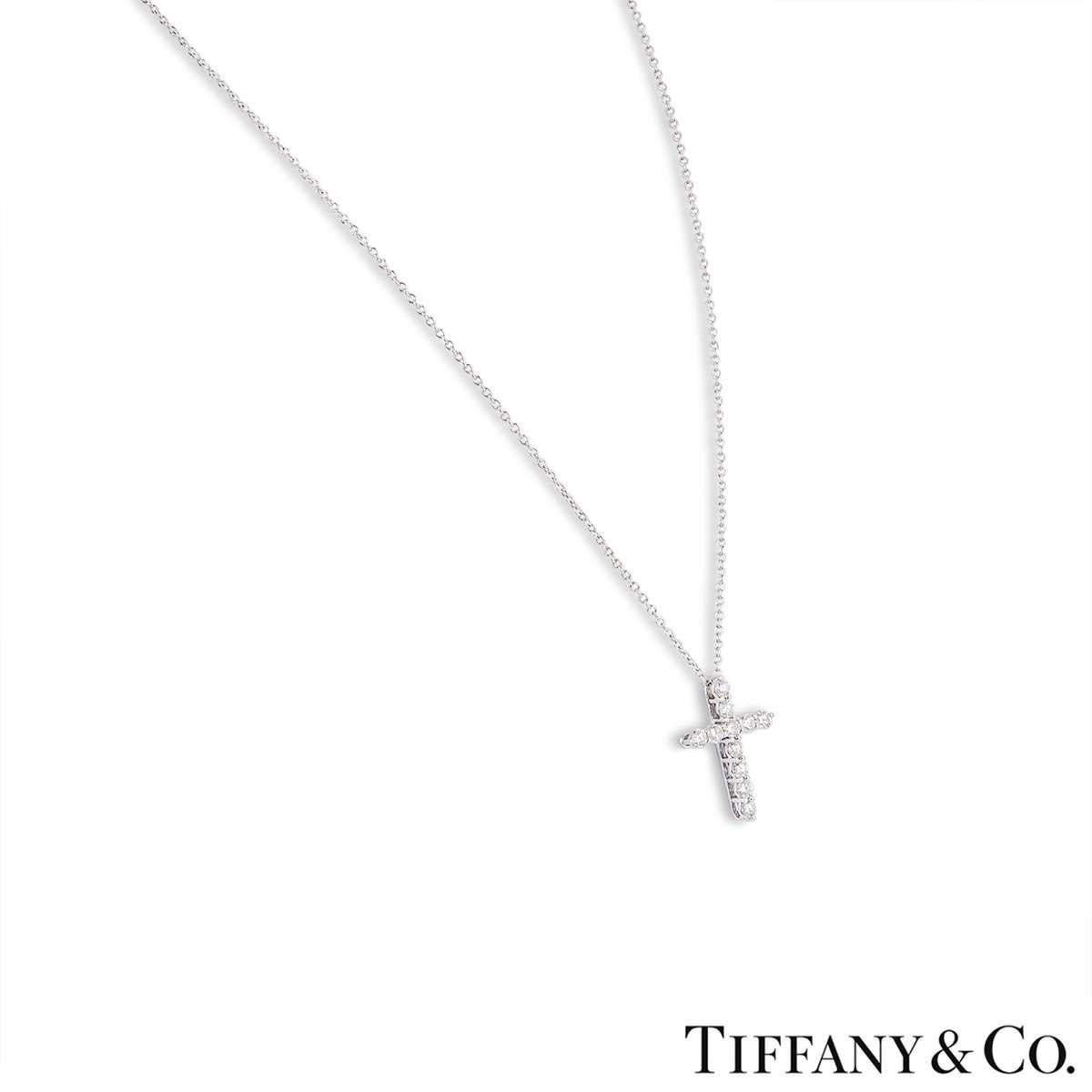 A diamond pendant in platinum by Tiffany & Co. The pendant features a cross motif which is made up of 11 round brilliant cut diamonds totalling 0.42ct. The pendant features a bolt spring clasp on a 17 inch chain and has a gross weight of 2.50