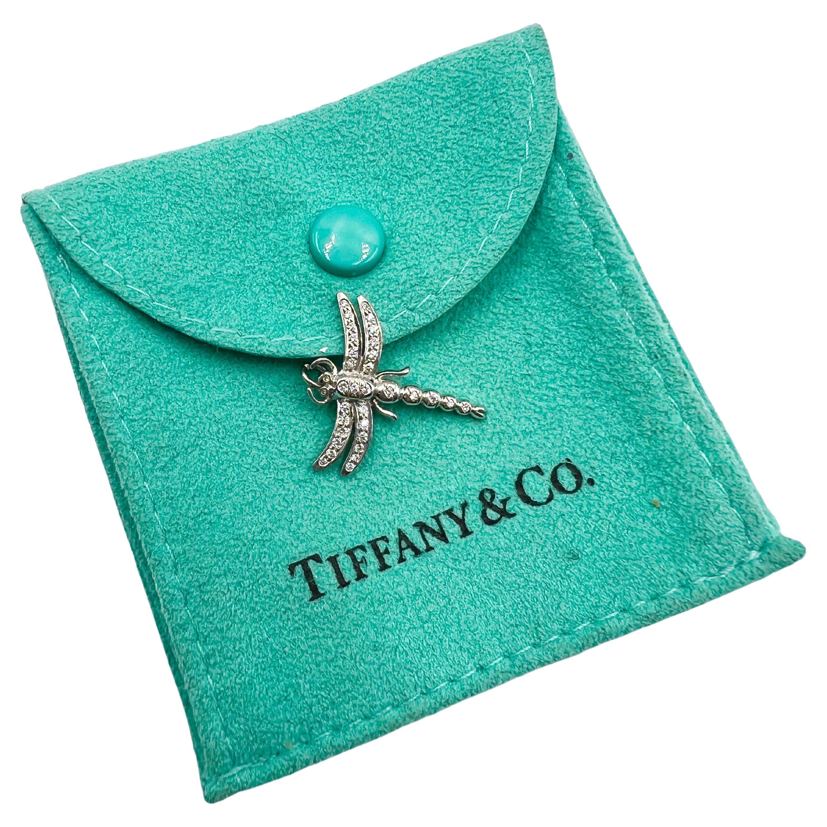 Adorable Tiffany & Co. dragonfly pendant charm in platinum and pave' set with round brilliant diamonds throughout the wings and body.  The dragonfly is delicately articulated with double wings, body and eyes all set with small round brilliant cut