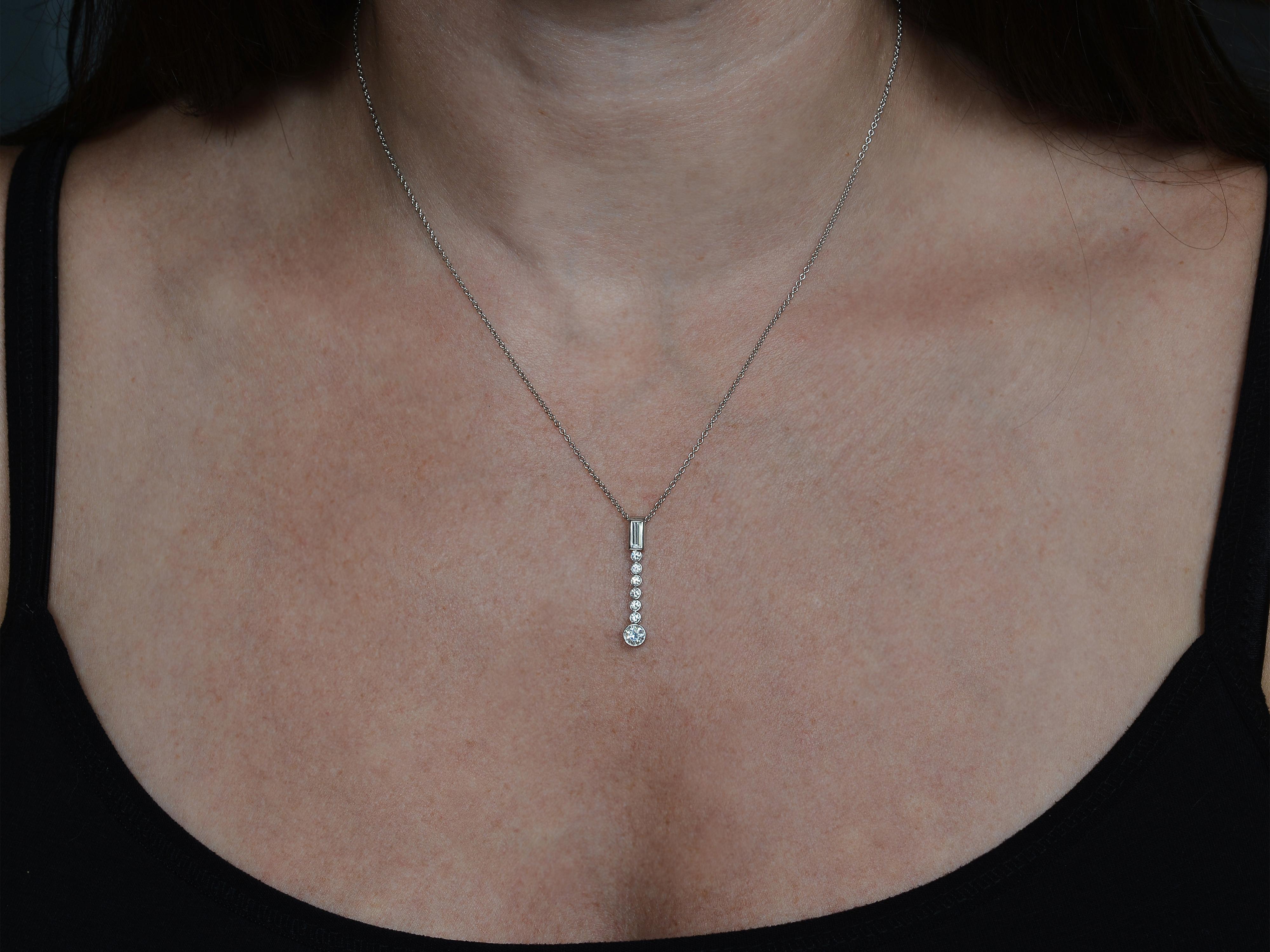 Platinum Tiffany & Co Diamond Necklace Featuring 7 Round Brilliant Cut Diamonds & 1 Baguette Cut Diamond of VS Clarity and F/G Color Totaling Approximately 0.50 Carats. 16 Inch Rolo/Cable Chain with 1 Inch Long Pendant. 