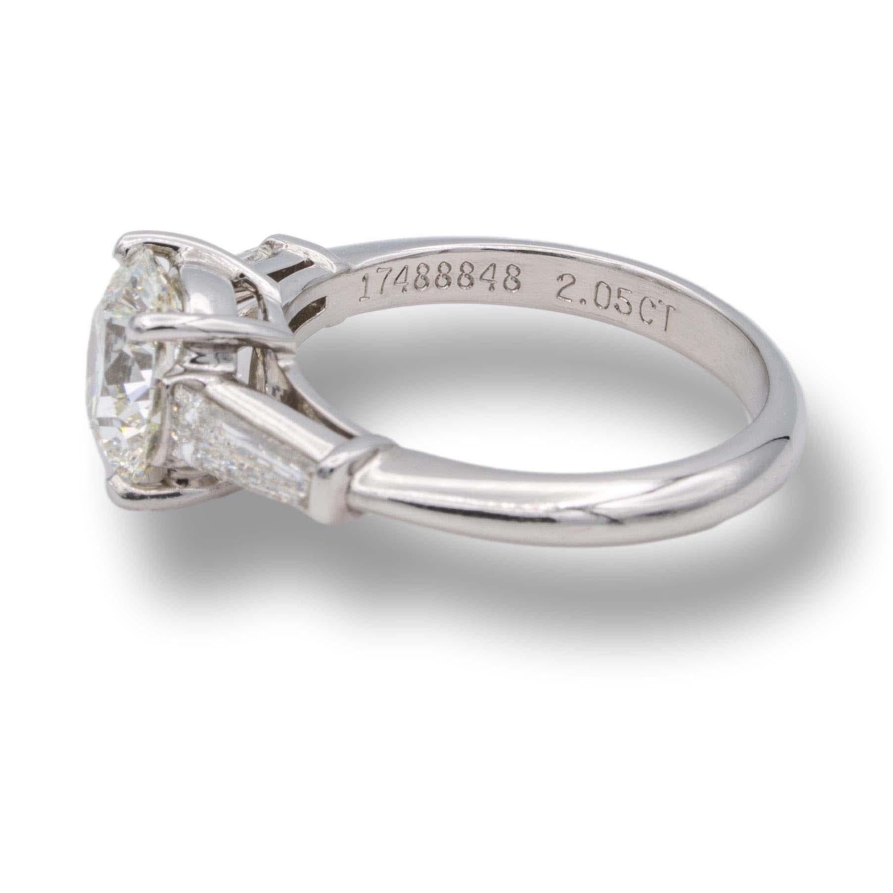 Tiffany & Co. Vintage diamond engagement ring finely crafted in platinum with a round brilliant cut center weighing 2.05 carats I color VVS1 clarity flanked by 2 tapered baguette diamond sides weighing 0.60 carats total weight I color VS clarity set