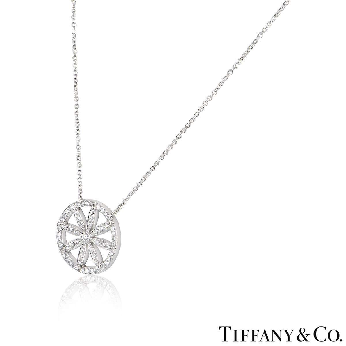 A beautiful platinum flower necklace by Tiffany & Co. The necklace features an openwork diamond set circular motif with a flower in the centre. There are 57 round brilliant cut diamonds with a total diamond weight of approximately 0.61ct. The motif