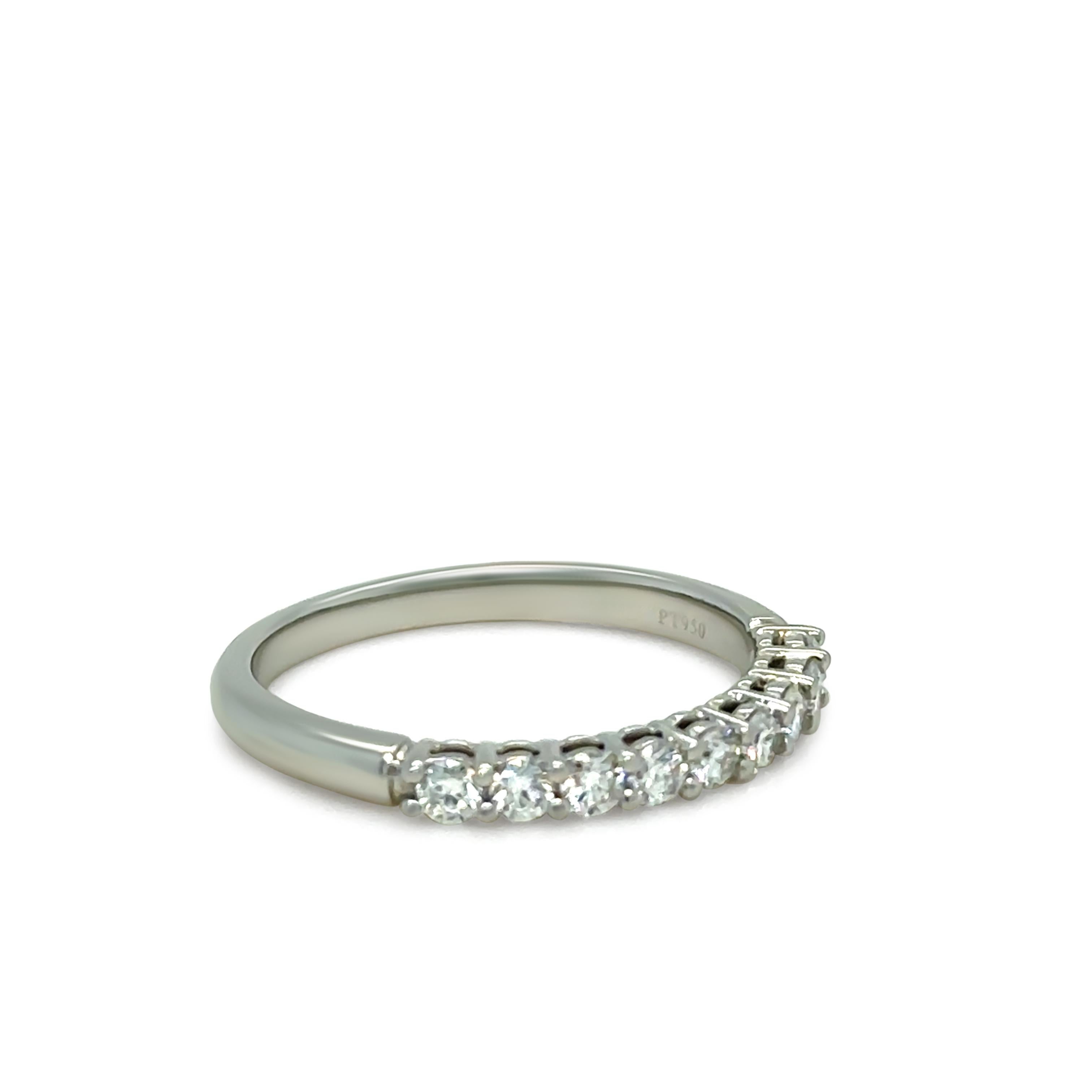 A timeless Tiffany Forever band ring, meticulously crafted in platinum and adorned with a half-circle of nine round brilliant-cut diamonds totaling 0.27ct. Each diamond is graded F in colour and VS in clarity, delivering an exquisite brilliance that