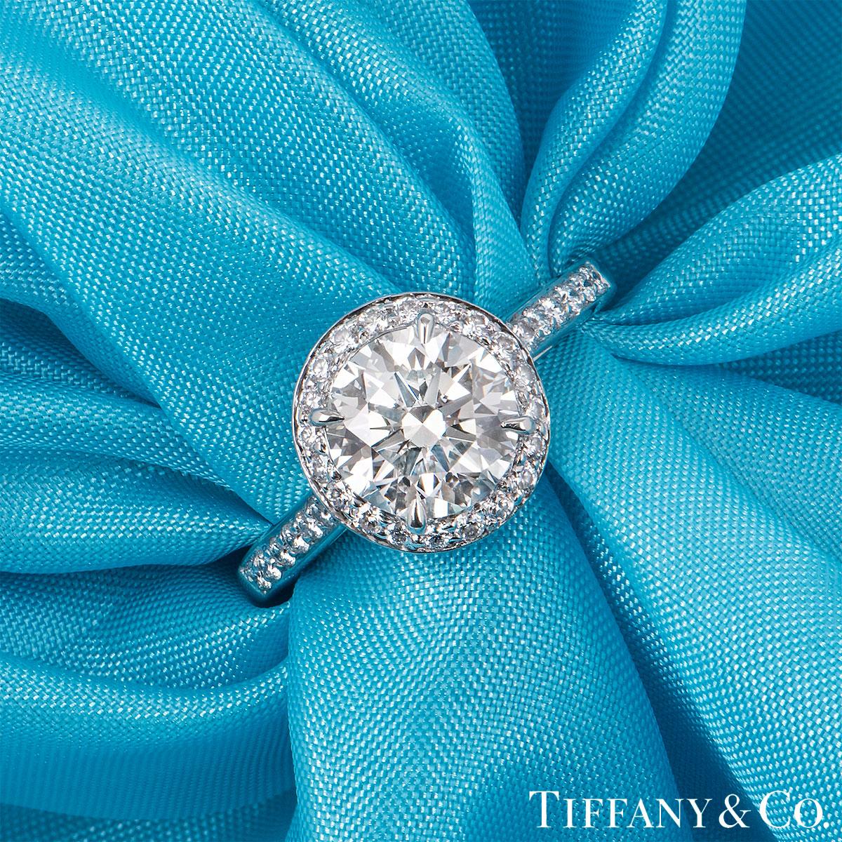 A beautiful platinum diamond Tiffany & Co. ring from the Soleste collection. The ring comprises of a round brilliant cut diamond in a 4 claw halo setting with a weight of 1.43ct, H colour and IF clarity. The halo of 32 round brilliant cut diamonds