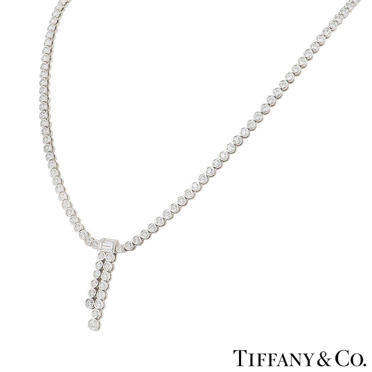 A beautiful platinum diamond necklace by Tiffany & Co. from the Jazz collection. The necklace features a diamond line in a rubover setting with a baguette cut diamond as a centre motif with 2 rows of diamond suspended beneath it. The round brilliant