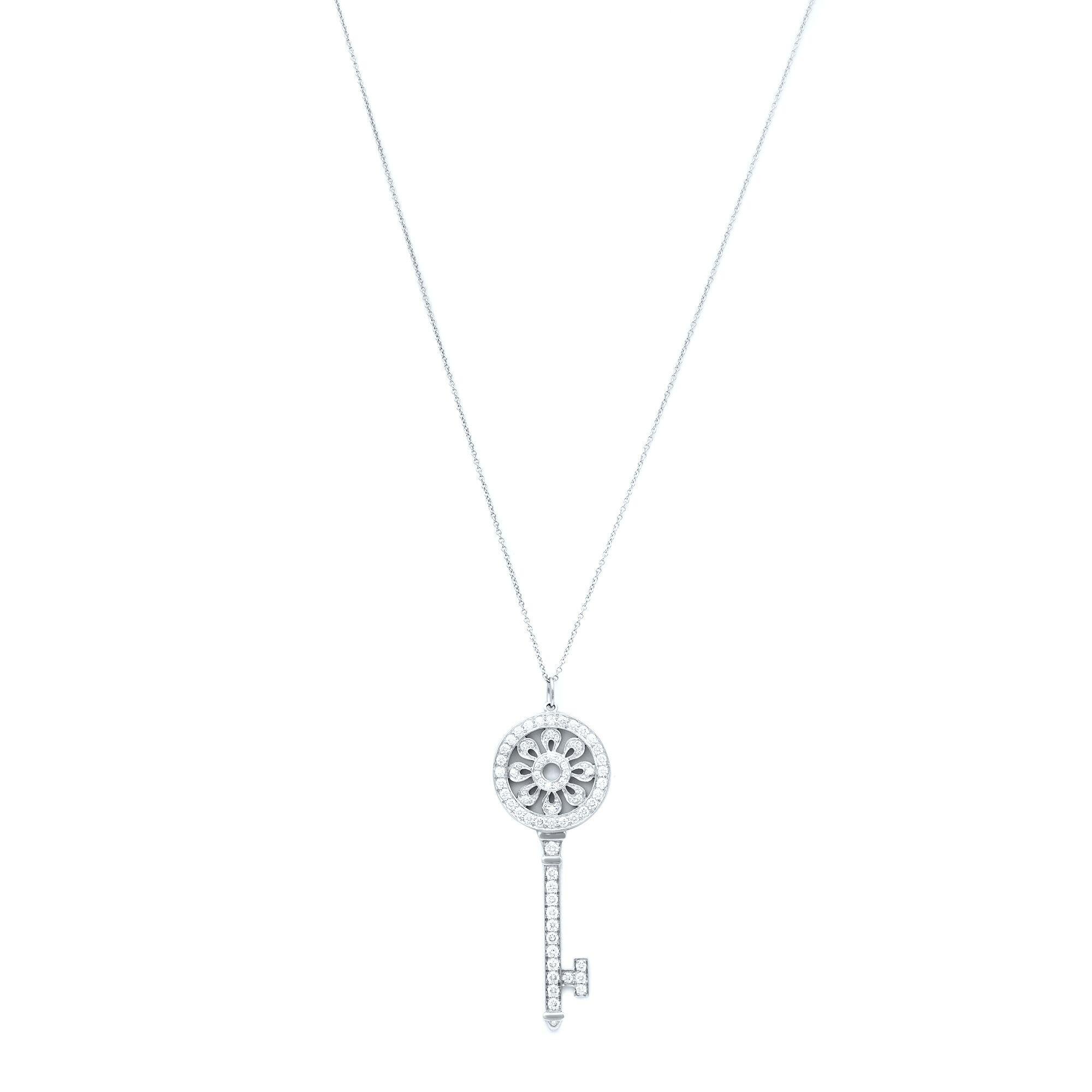 Tiffany & Co. key pendant which is made in fine platinum and pave-set with 1.18 carats of round brilliant diamonds. The pendant measures 2.5 inches in length and features an elegant flower design inside the key, completed by a 31 inch tiny link
