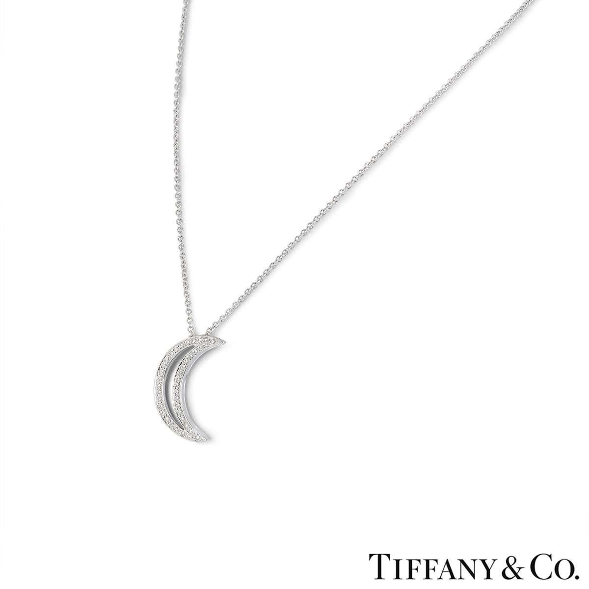A platinum Moon pendant by Tiffany & Co. The pendant features an openwork Moon motif set with round brilliant cut diamonds totalling 0.16ct. The motif measures 2cm in length and comes on an original 16 inch chain, complete with bolt ring clasp. The