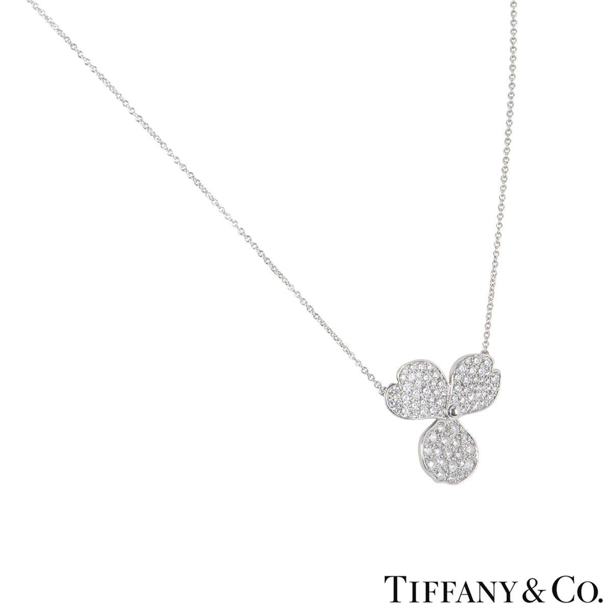 A platinum diamond pendant by Tiffany & Co. from the Paper Flowers collection. The pendant features a flower motif with 3 petals pave set with round brilliant cut diamonds with a total diamond weight of 0.85ct. The flower motif measures 2.10cm by