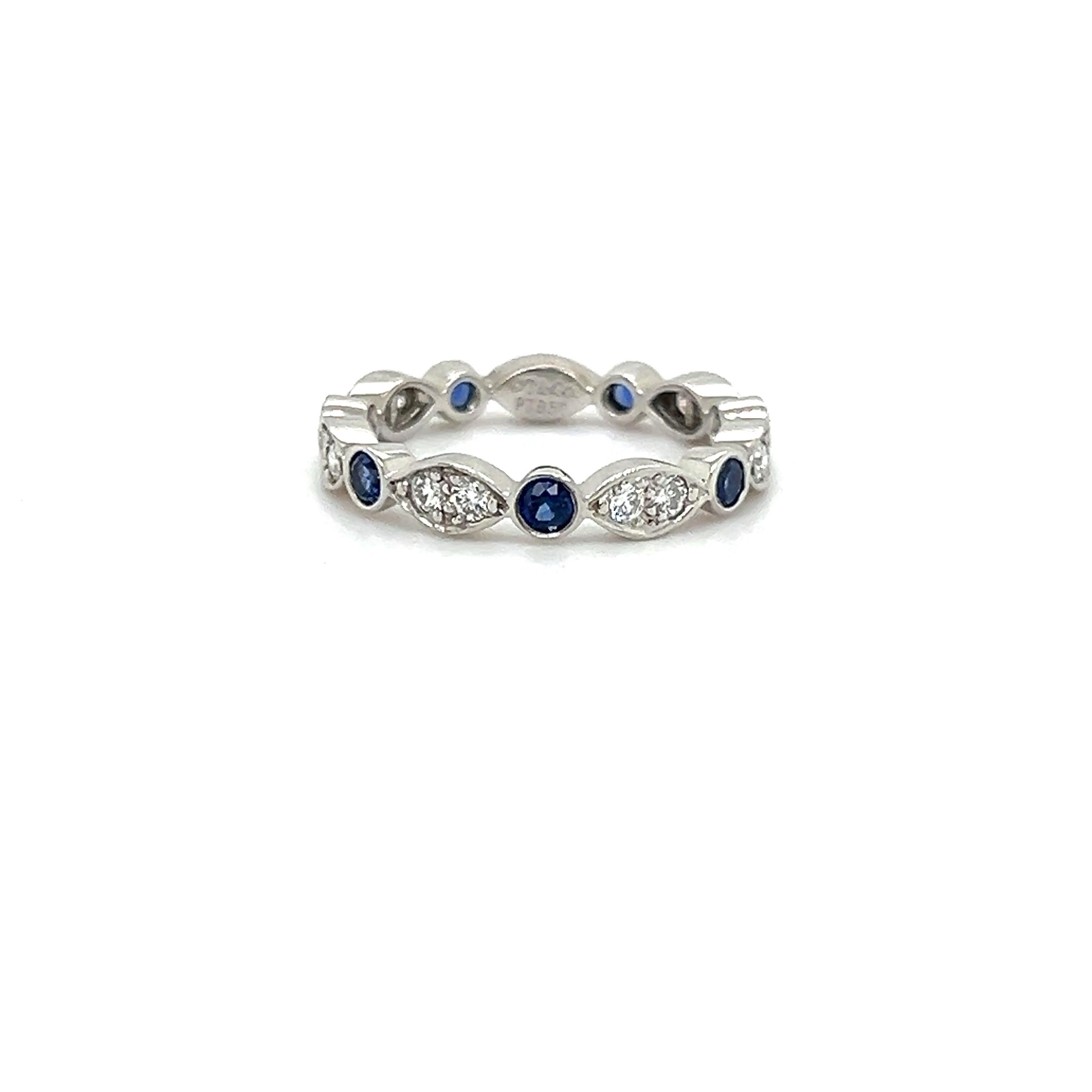 Beautiful ring from famed designer Tiffany & Co. This elegant ring is crafted in platinum and showcases diamonds and blue sapphires that are bezel set in marquise and round  bezel set shapes. The ring is from the 