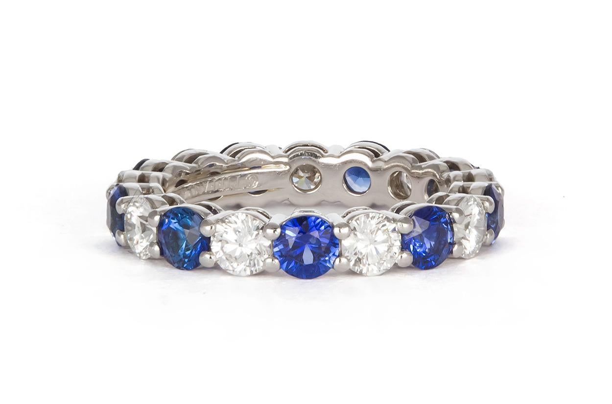 We are pleased to offer this Authentic Tiffany & Co. Platinum, Diamond & Sapphire Tiffany Embrace Band Ring. It features approximately 1.35ctw F-G/VVS-VS Round brilliant Cut Diamonds and 1.80ctw Round Brilliant Cut Blue Sapphires set in .950