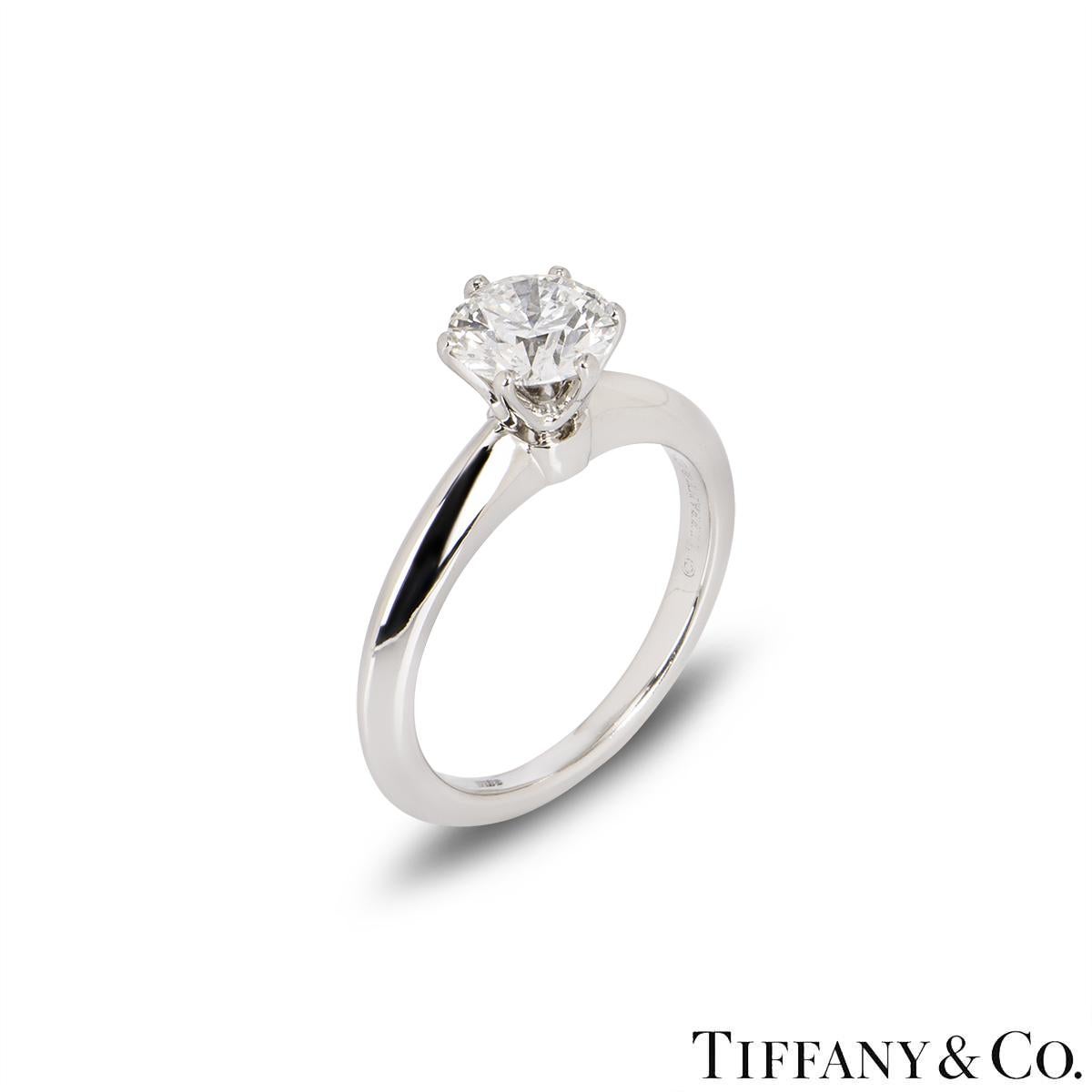 A classic platinum diamond ring by Tiffany & Co. from the Setting collection. The ring comprises of a round brilliant cut diamond in a platinum six claw setting with a weight of 1.08ct, H colour and VS2 clarity. The diamond scores an excellent