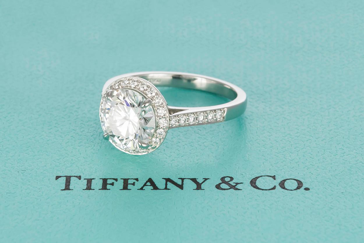 We are pleased to offer this Guaranteed Authentic Tiffany & Co GIA Certified Platinum Diamond Embrace Halo Engagement Ring. This absolutely stunning ring features Tiffany & Co's Platinum Embrace Diamond Halo Setting, a truly timeless design.