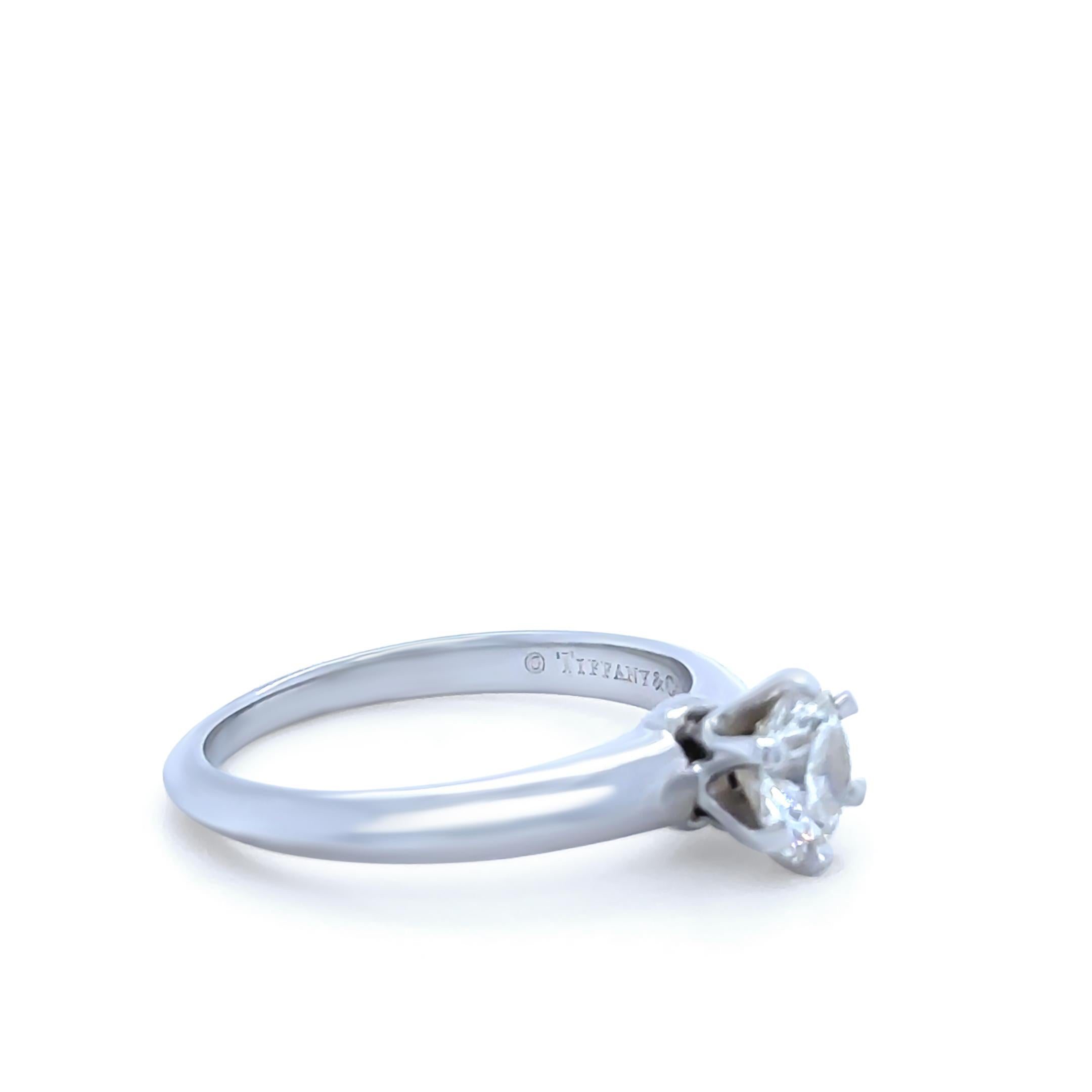 A timeless Tiffany & Co Platinum solitaire ring, featuring a 0.58ct Round Brilliant Cut Diamond of I Colour and VS2 Clarity, expertly prong set in the classic Tiffany Setting. This elegant piece embodies Tiffany’s signature style and precision,