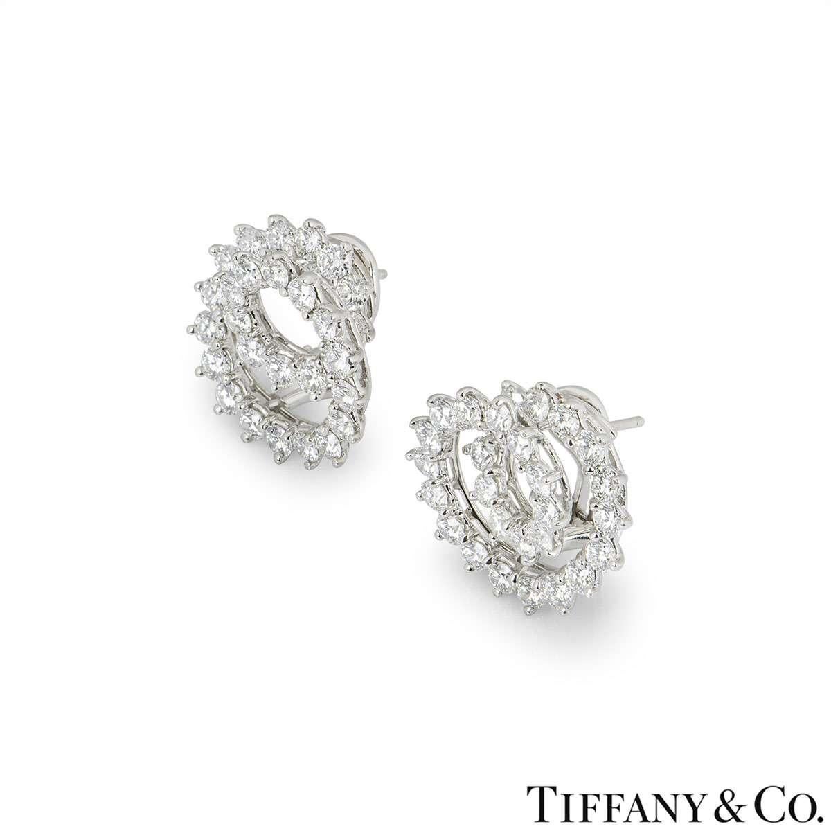 A pair of platinum swirl earrings by Tiffany & Co. The earrings are composed of 56 claw set round brilliant cut diamonds totalling approximately 2.80ct. The diamonds are predominantly G+ colour and VS clarity. The earrings measure 2cm in diameter