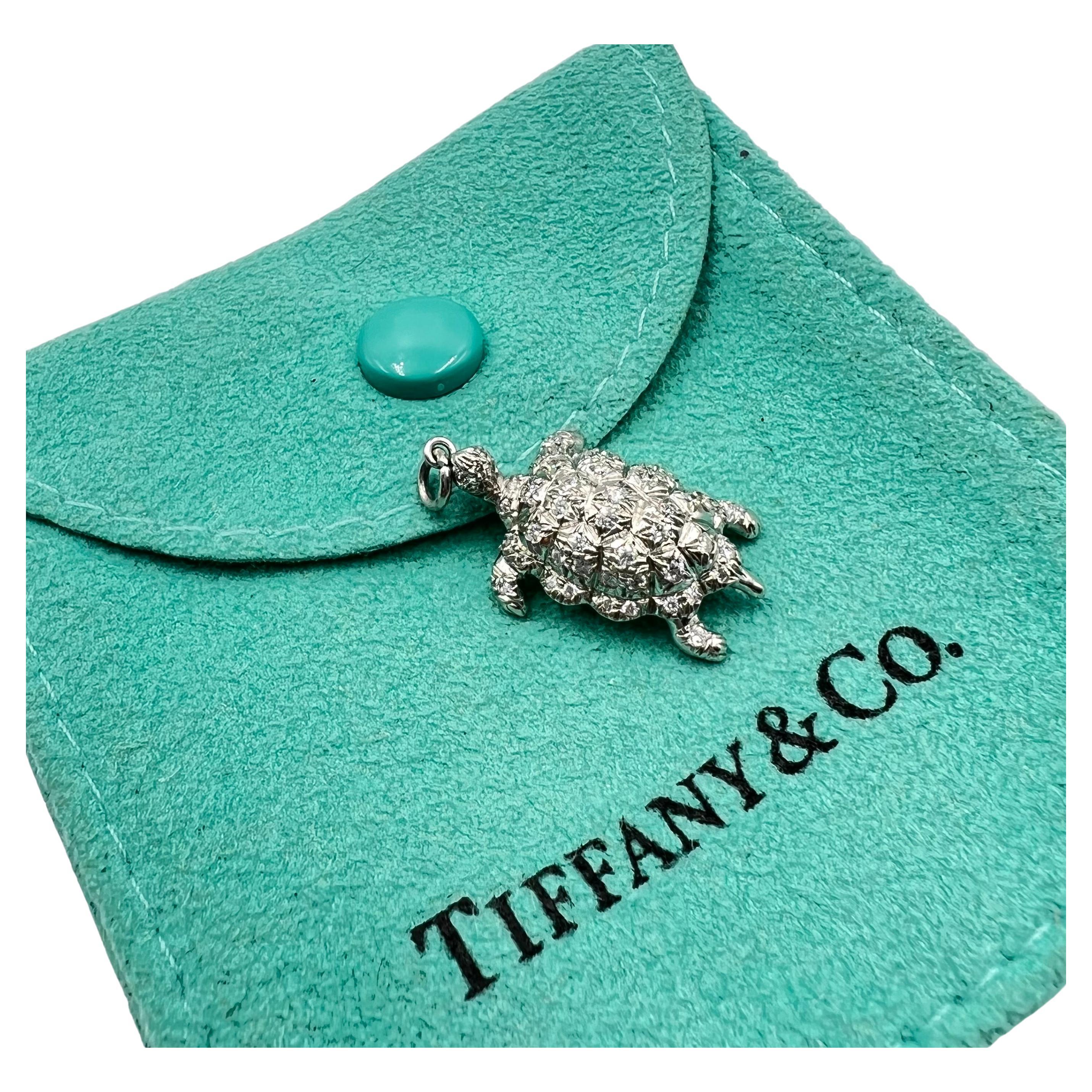 Adorable Tiffany & Co. turtle pendant charm in platinum and accented with round brilliant diamonds throughout the shell, head, feet and head.  Shell body is dimensional and curved with a nicely finished under gallery signed 