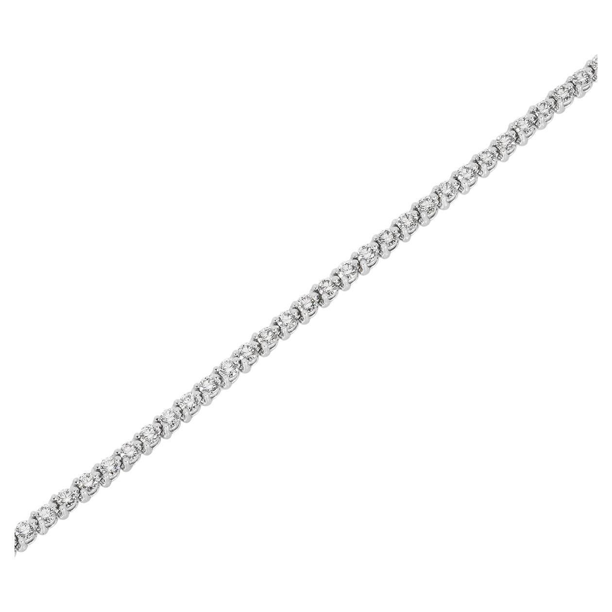 A radiant platinum diamond tennis bracelet by Tiffany & Co. from the Tiffany Victoria collection. The line bracelet is set with 54 round brilliant cut diamonds leading to a diamond clasp set with 4 marquise cut diamonds with an approximate combined