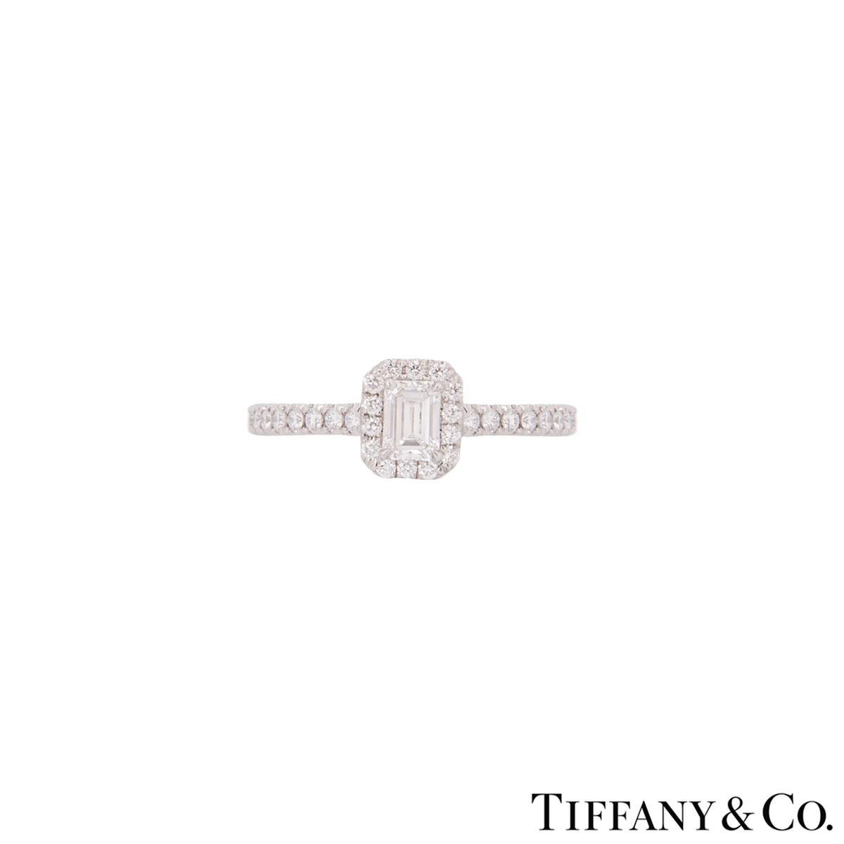 A stunning platinum diamond halo ring by Tiffany & Co. from the Soleste collection. The ring features an emerald cut diamond in a four claw setting in the centre with a weight of 0.25ct, predominantly F-G in colour and VS clarity. The diamond is