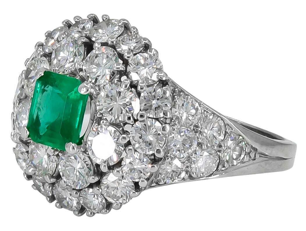 Gorgeous emerald and diamond ring.  Made and signed by TIFFANY & CO.  Set in platinum.  Emerald cut emerald, approximately 0.50 cts.  Surrounded by over 3 carats of diamonds.  Exquisitely hand crafted with no detail left unnoticed.  The diamonds