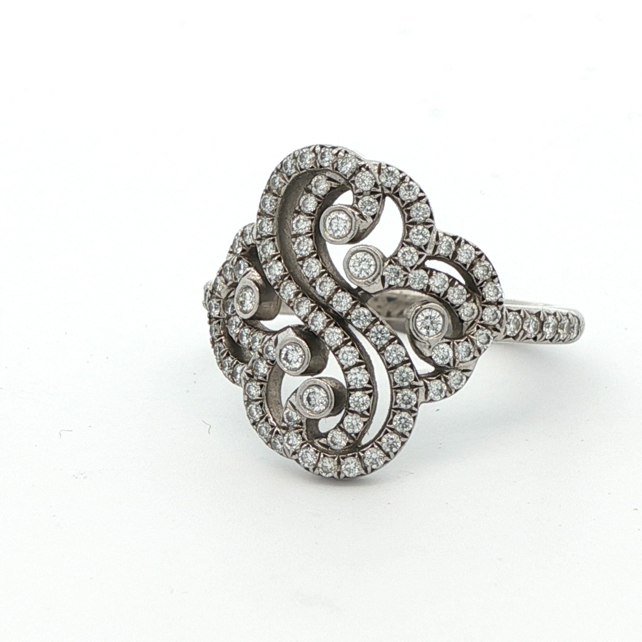 Cette magnifique bague à double cœur enchantée a été fabriquée par la célèbre maison Tiffany & Co. en platine et diamants. La bague comporte plus de 100 diamants d'un blanc éclatant, d'une pureté VS et d'une couleur G/H. L'anneau est arrondi de