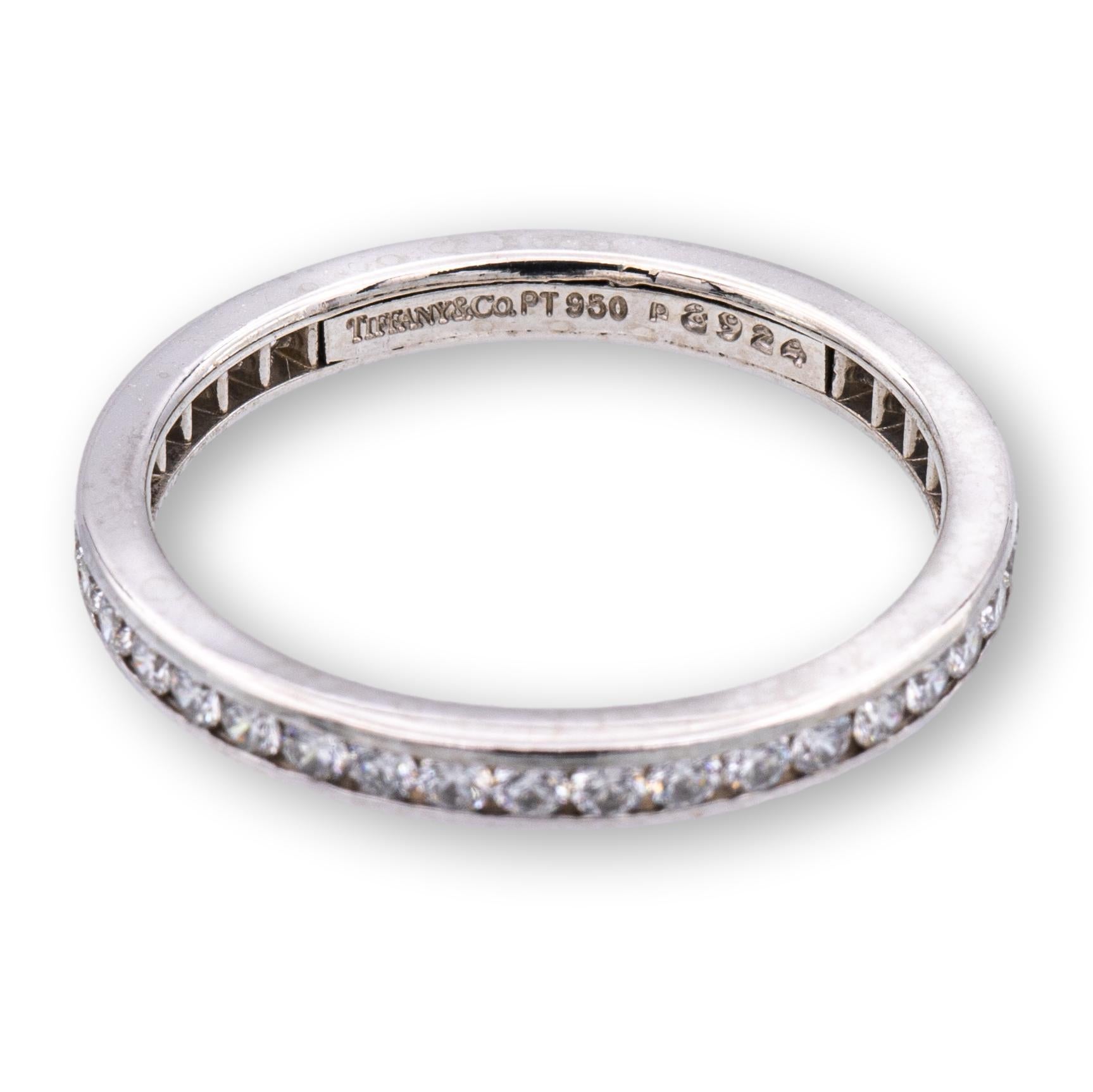 Tiffany & Co. wedding band ring finely crafted in platinum featuring 40 round brilliant cut diamonds weighing 0.40 carats total weight set all the way around in a full circle channel setting. Ring measures 2mm wide. Fully hallmarked with Tiffany