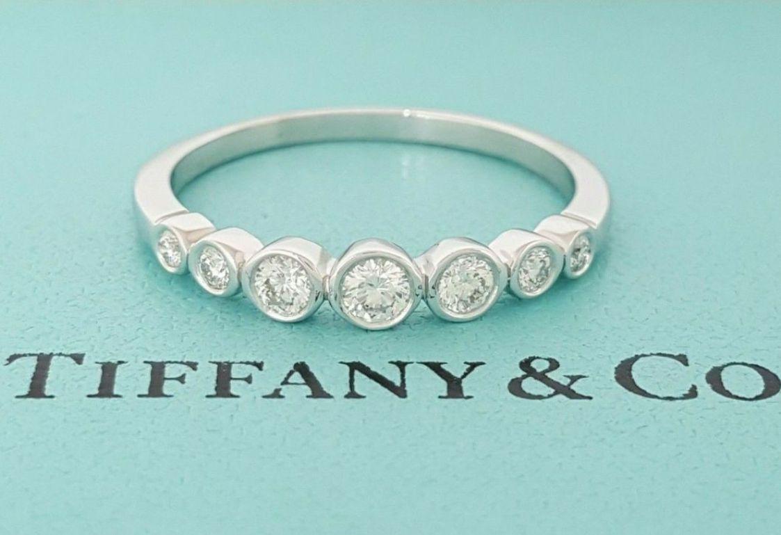 TIFFANY & Co. Platinum Graduated Diamond Jazz Band Ring 7.5

Metal: Platinum
Size: 7.5
Weight: 4.20 grams 
Diamond: 7 round brilliant diamonds, carat total weight .32 
Hallmark: ©TIFFANY&CO. Pt950 
Condition: Excellent condition, like new. It comes