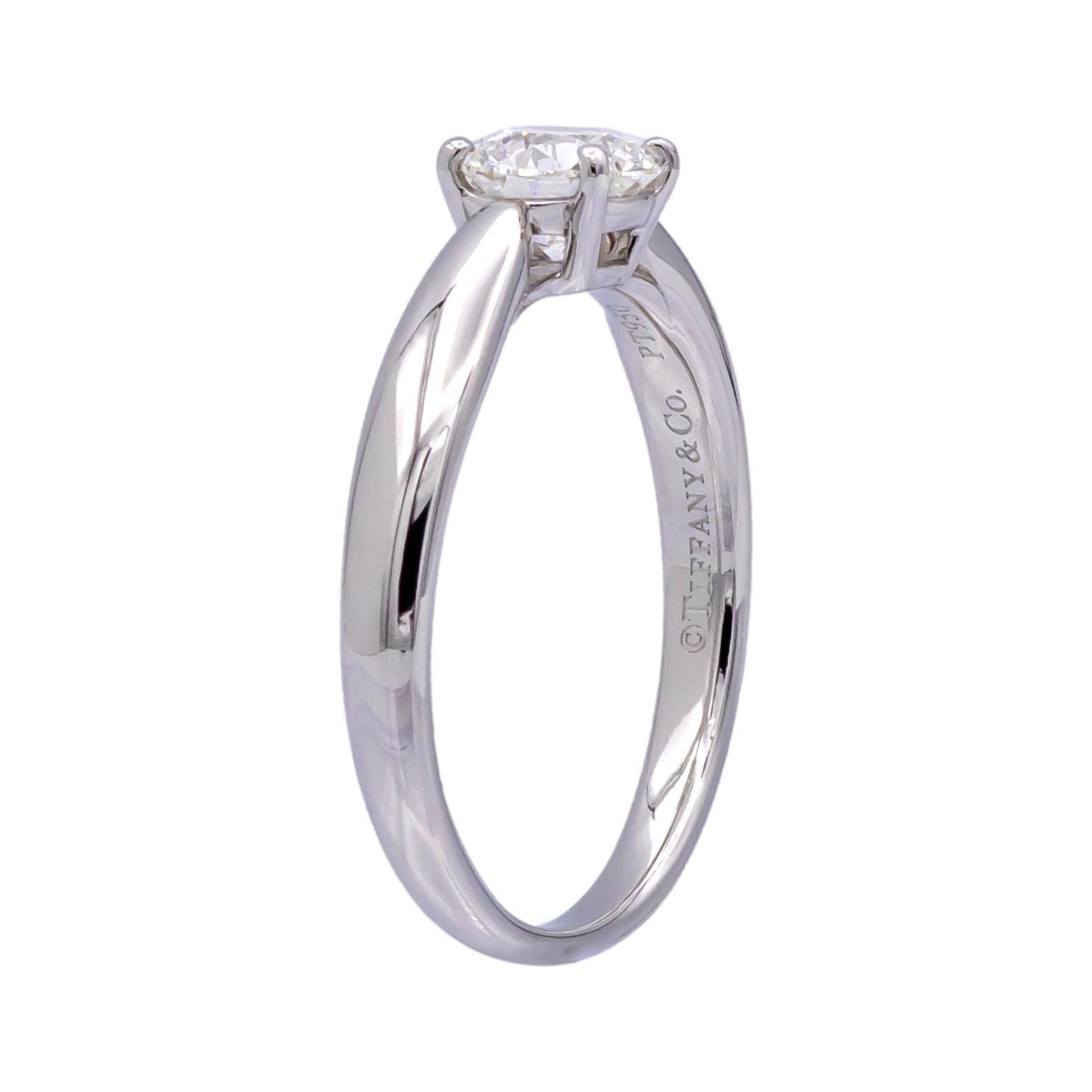 This stunning Tiffany & Co. Harmony engagement ring features a .61 carat Round Brilliant cut diamond as the centerpiece, graded G in color and VS1 in clarity. The diamond is set in platinum. Both the center diamond and ring are inscribed with