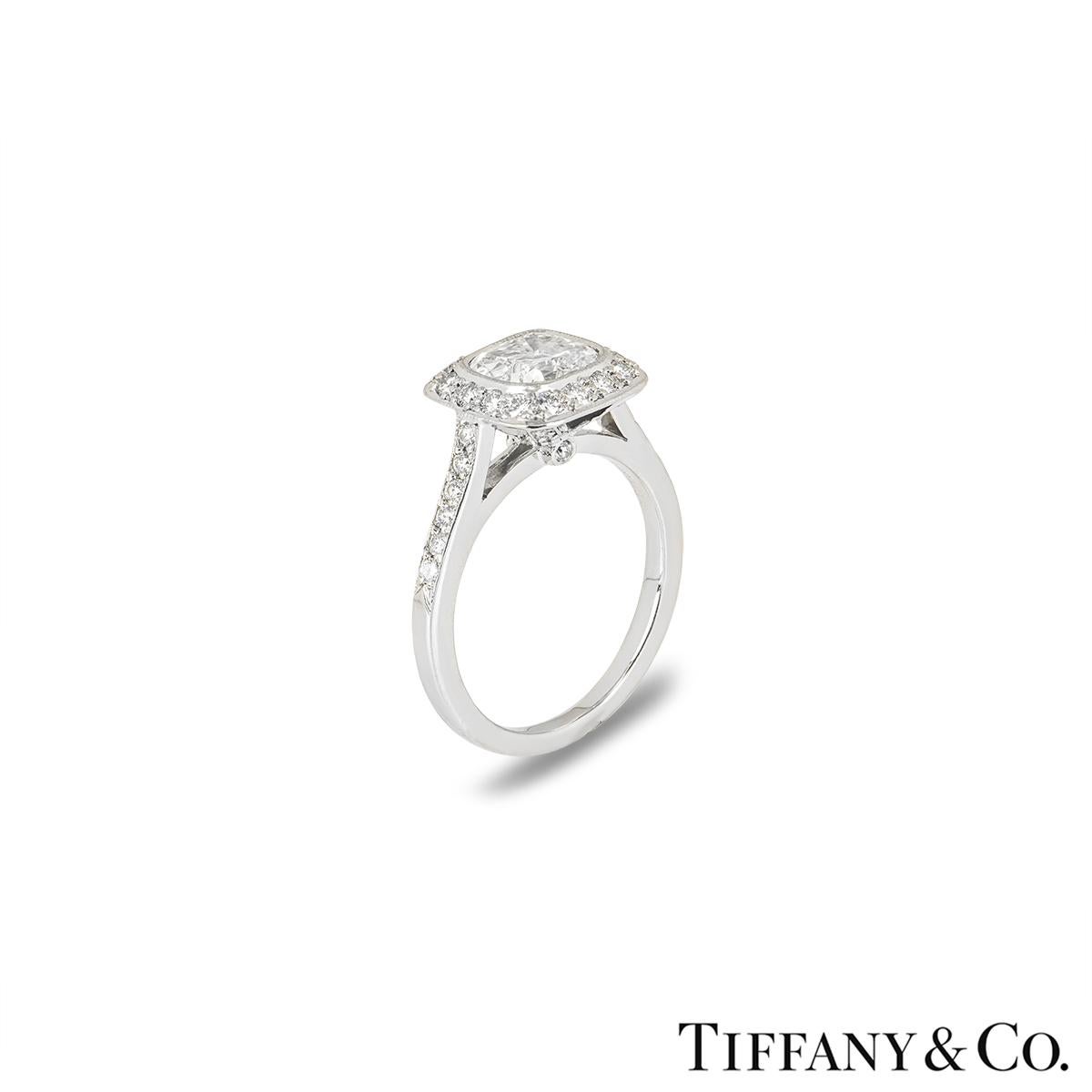 A stunning platinum diamond ring from the Legacy collection by Tiffany & Co. The ring is set to the centre with a 1.34ct modified cushion cut diamond, G colour and VS1 clarity. The diamond is complemented by diamond set shoulders and halo totalling