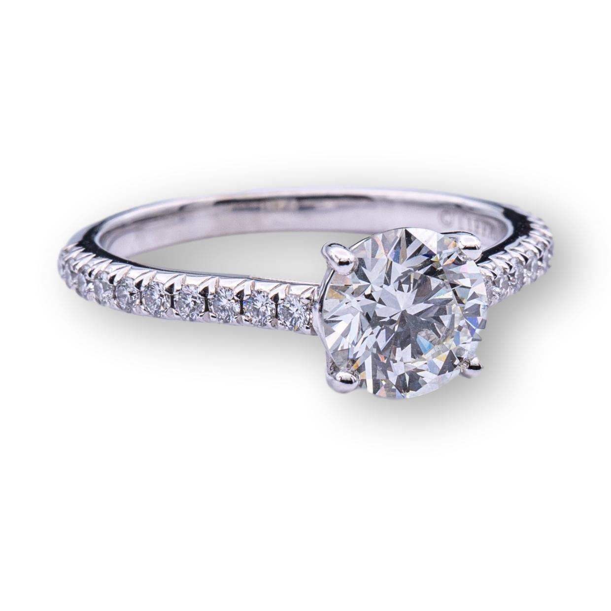 Tiffany & Co. engagement ring from the Novo collection finely crafted in platinum featuring a round brilliant diamond center weighing 0.95 carats , I color , VVS2 clarity set in a 4 prong basket setting adorned with 20 bead set round brilliant cut