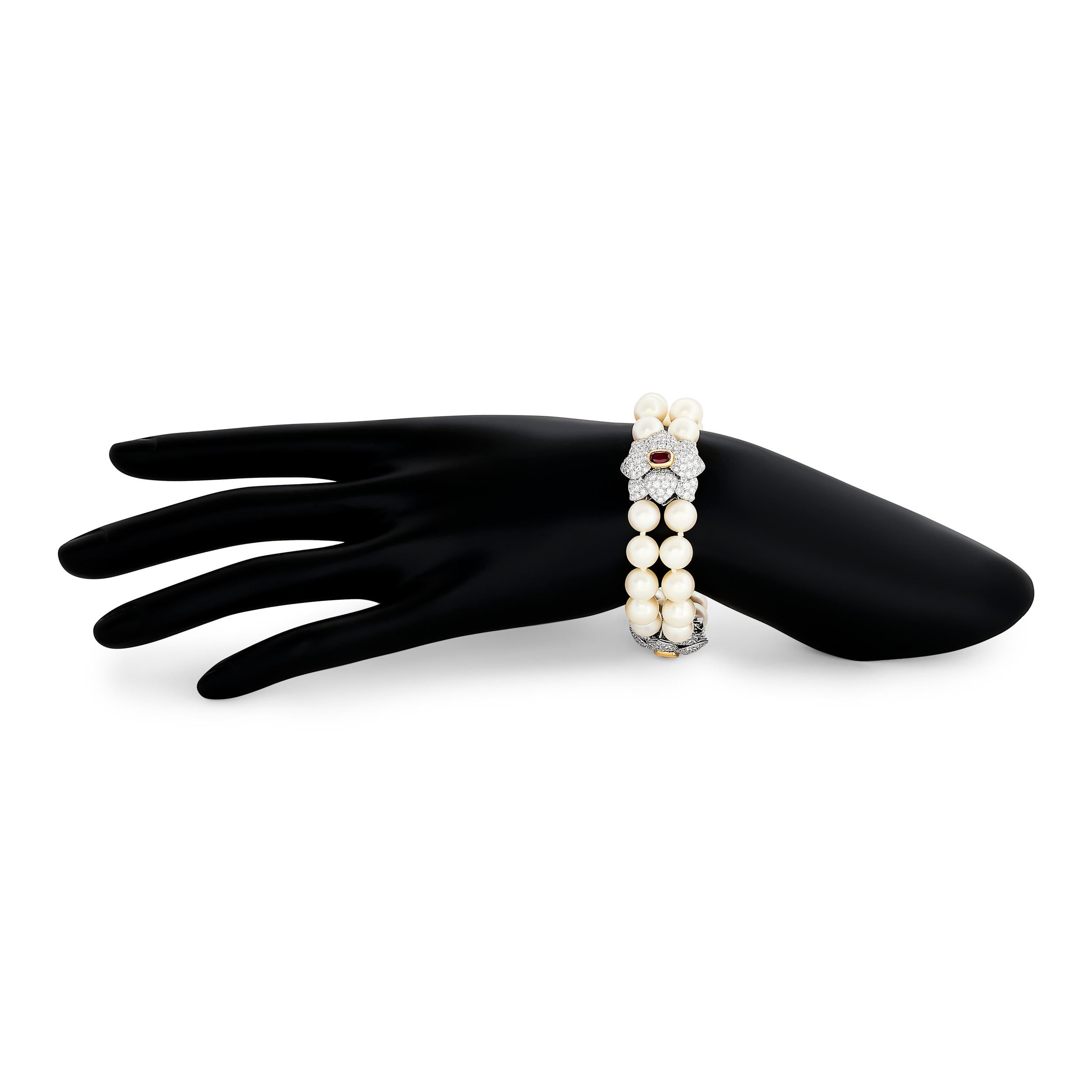 Un bracelet en platine de Tiffany & Co., orné de deux rangées de perles brillantes et de trois délicates fleurs en diamant, chacune dotée d'un centre en rubis captivant.

30 perles ~8.75-8.80mm
3 rubis ovales d'un poids total de 1,80 carat
diamants