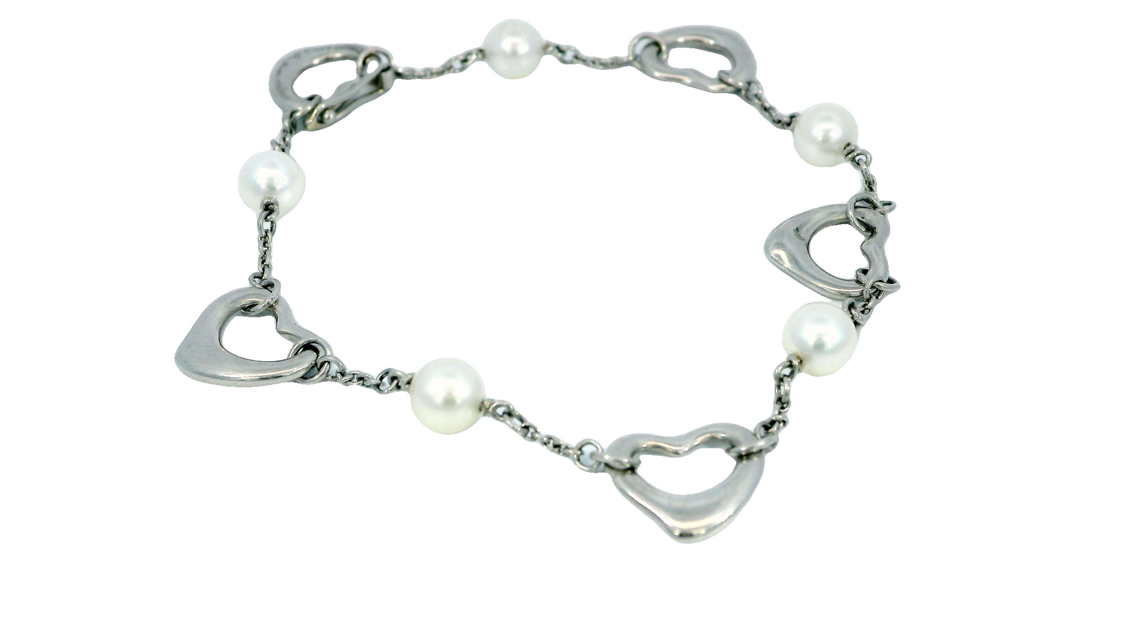 Contemporary Tiffany & Co. Platinum Heart and Pearl Bracelet. This elegant bracelet is crafted in platinum, featuring open heart links interspersed with lustrous pearls. The design is delicate and refined, showcasing the iconic style of Tiffany &