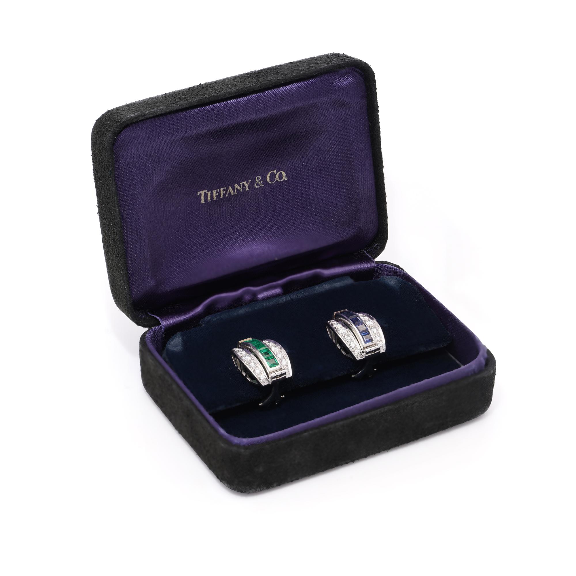 These reversible earrings by Tiffany & Co. are crafted from platinum and designed in a slightly curved rectangular shape. Each earring features a reversible mechanism, allowing the central row to be changed between square-cut emeralds and square-cut