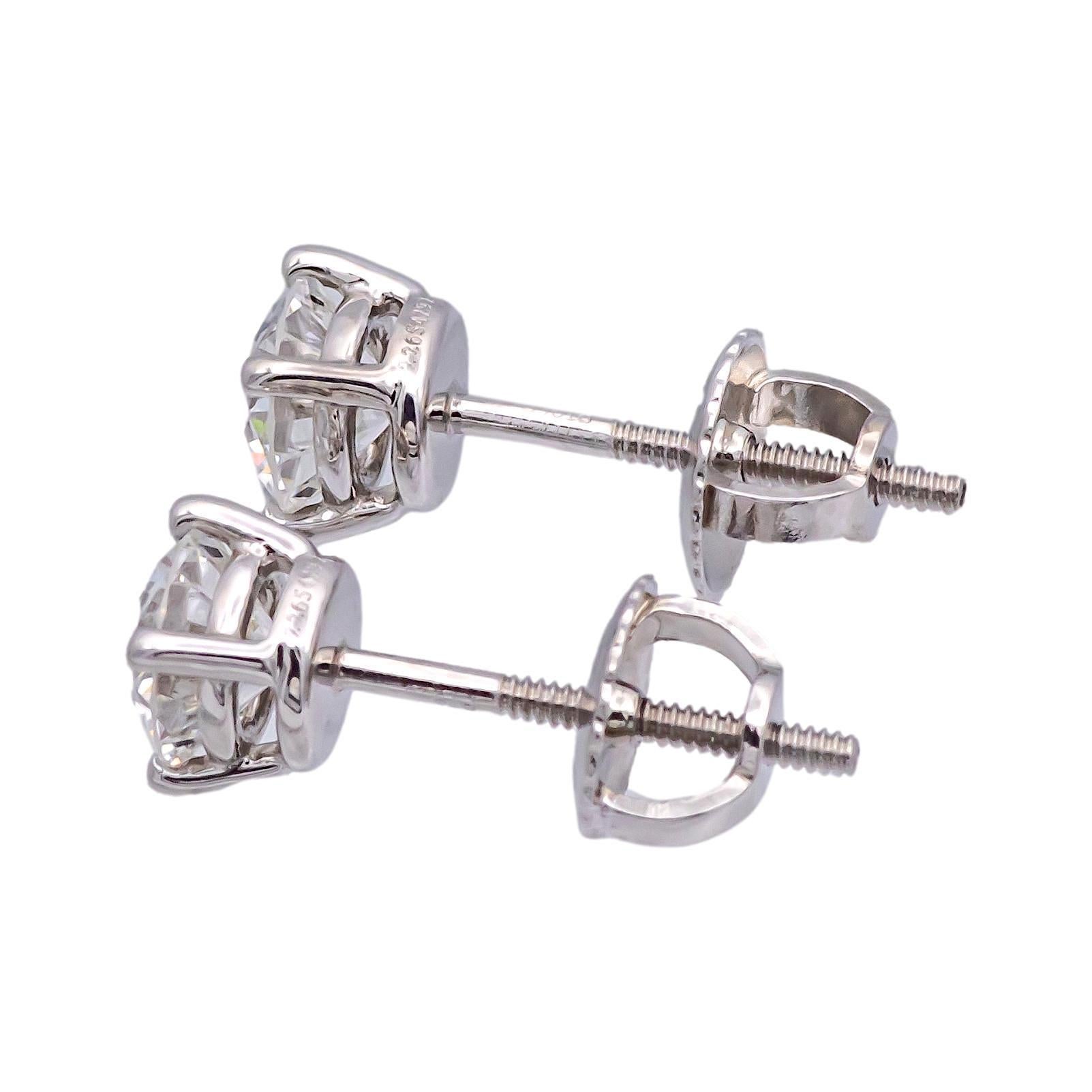 Pair of Tiffany & Co. Diamond Stud earrings finely crafted in a Platinum 4 prong basket setting featuring two perfectly matched round brilliant cut diamonds weighing 0.95 carats total weight. One round brilliant diamond weighs 0.47 carats graded G