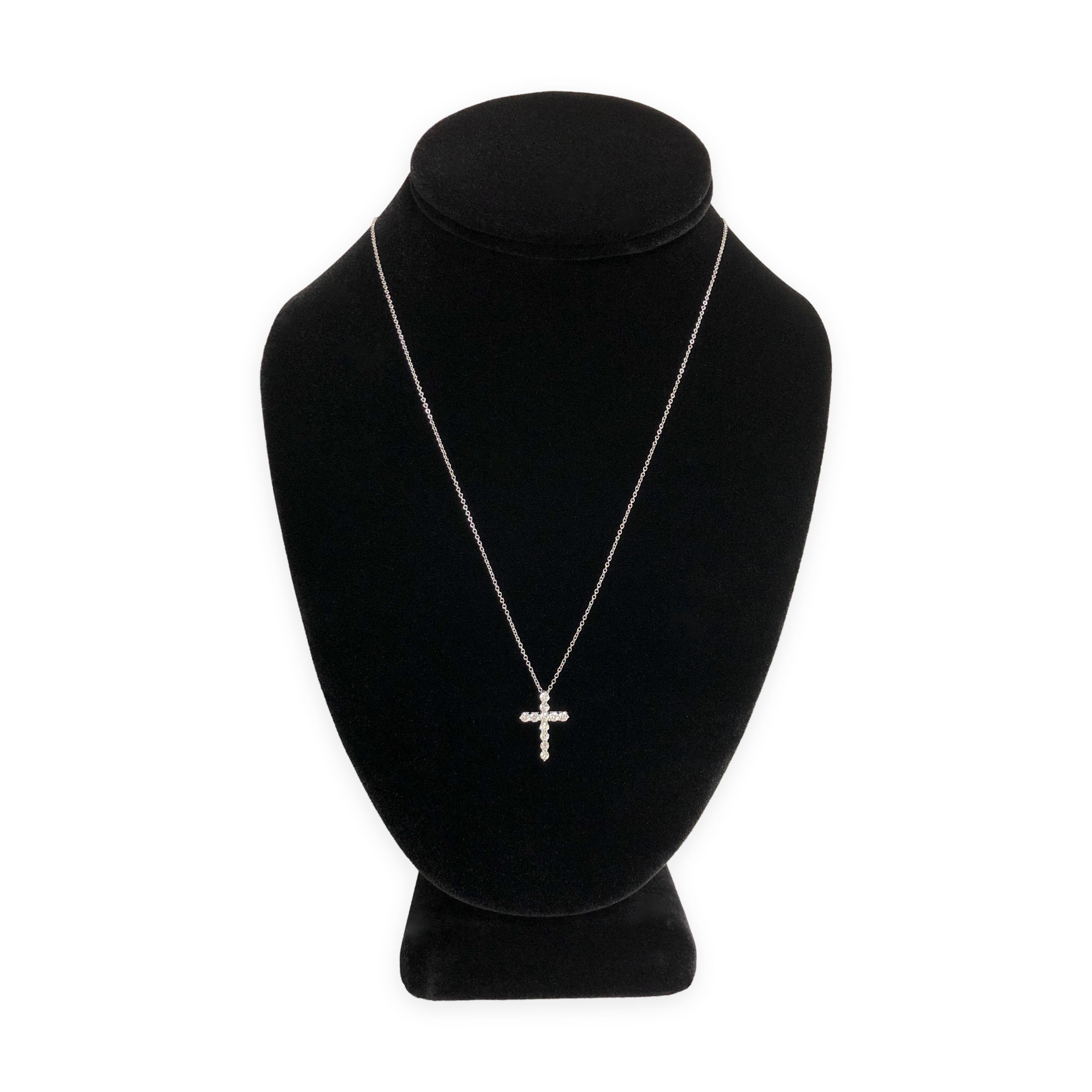 This elegant Tiffany & Co. cross pendant necklace is crafted in platinum and features 11 round brilliant cut diamonds totaling 0.41 carats. The diamonds are securely prong set in a refined cross formation, offering exceptional brilliance and