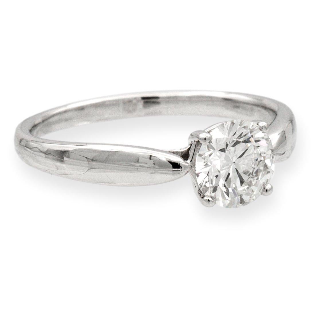 Tiffany & Co. round diamond engagement ring from the Harmony collection finely crafted in platinum featuring a round brilliant cut diamond center weighing 1.01 carats H color VVS2 clarity. This ring has a tapered shank design. Ring is fully